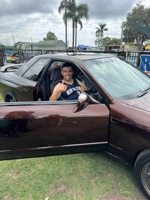 Man sitting in car with his thumbs up and smiling