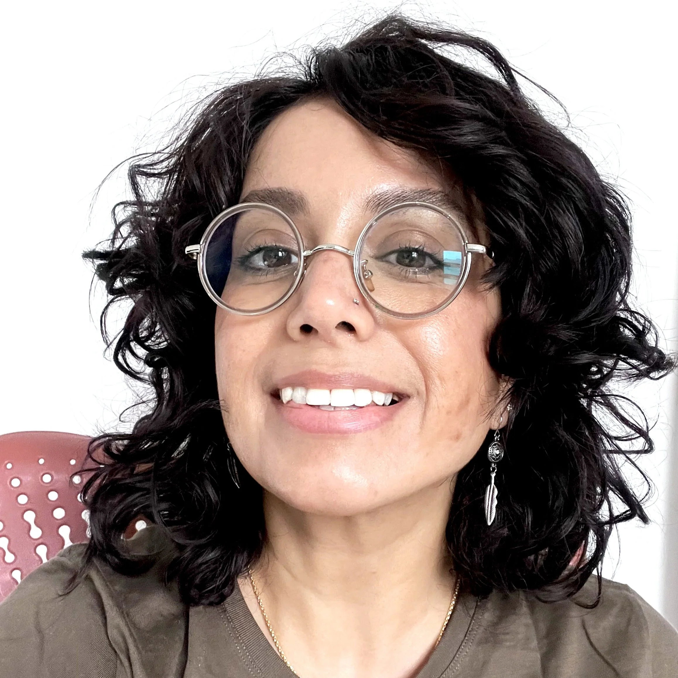 A person sitting on a computer chair and smiling at the camera.