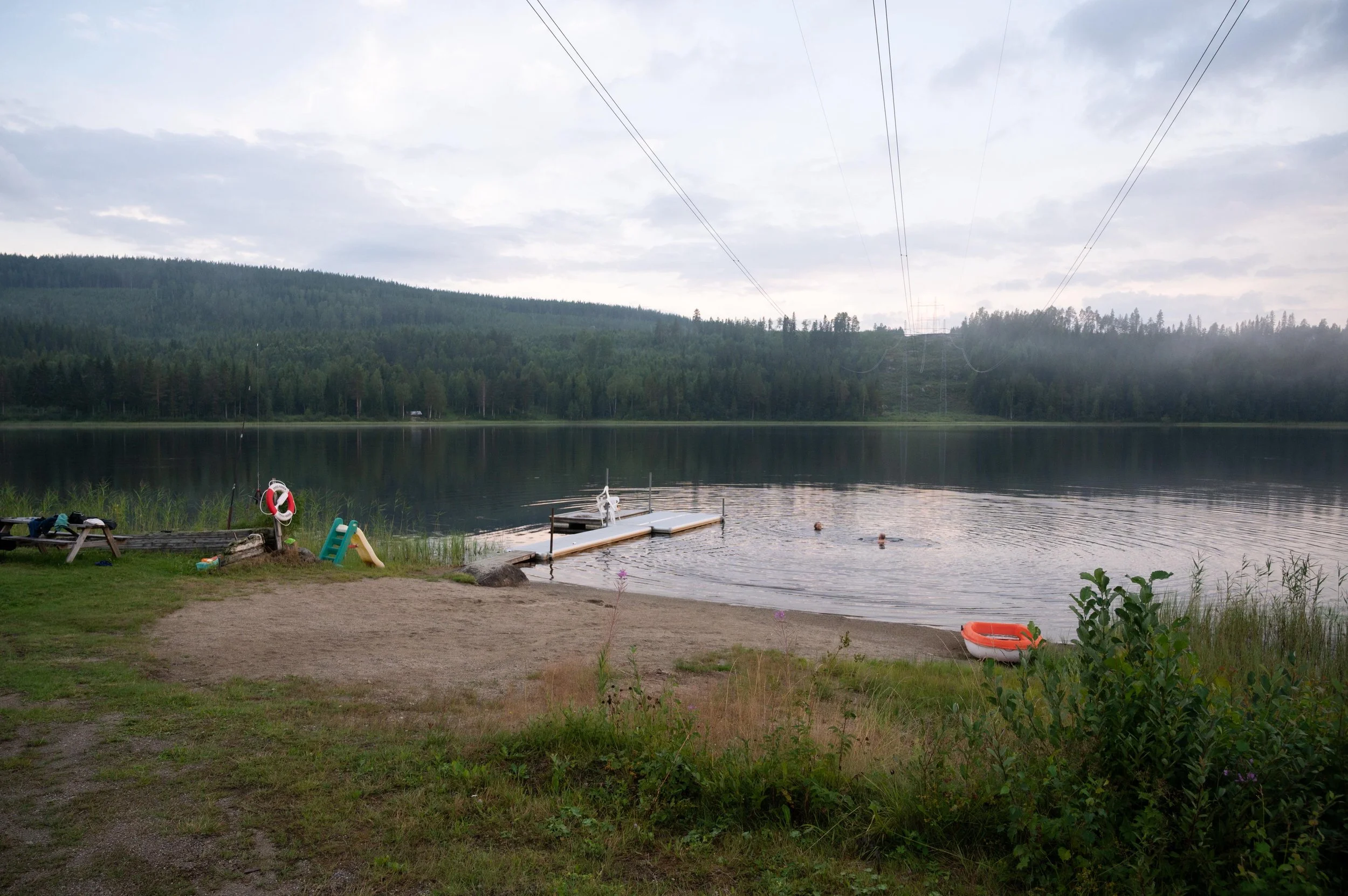 Symbol för badplats med simmande person och vatten