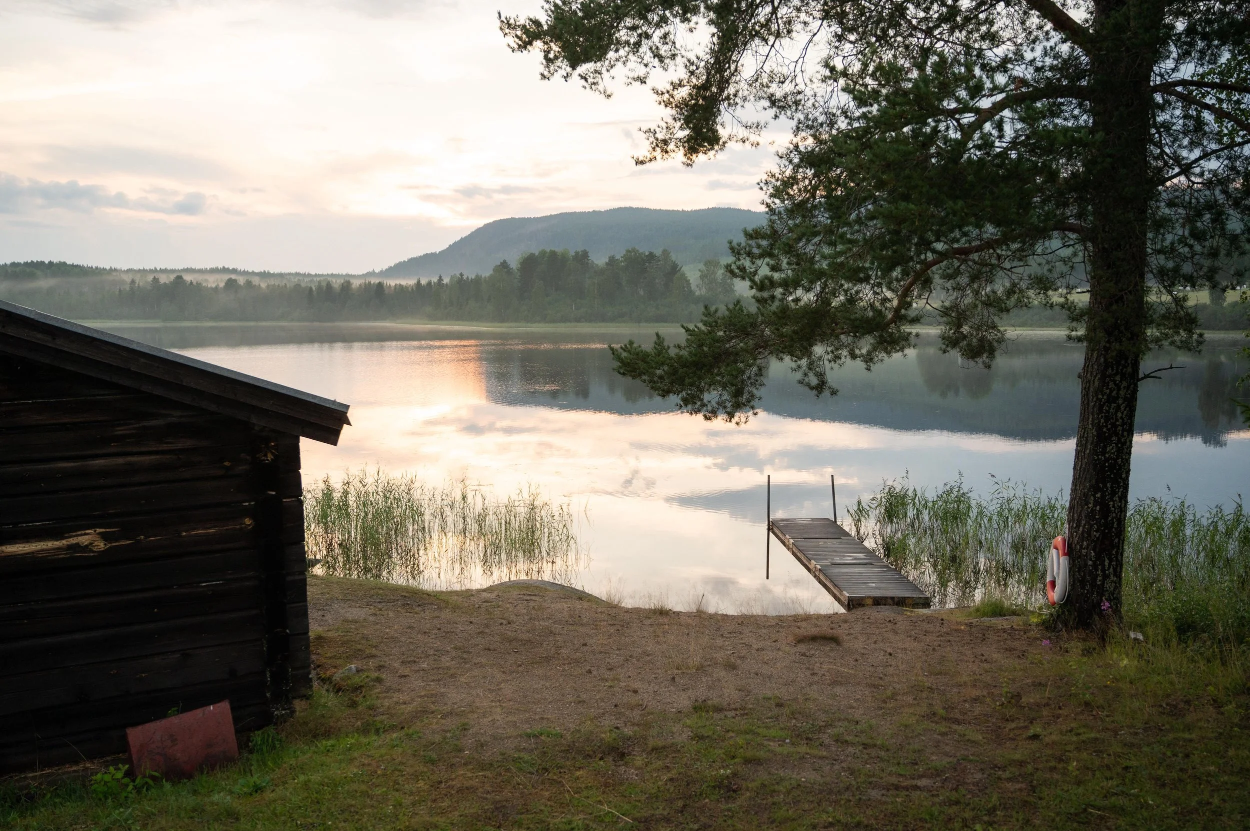 Simvarningsskylt med en silhuett av en person och vågformade linjer, indikerar att badplats eller simning är tillåtet.