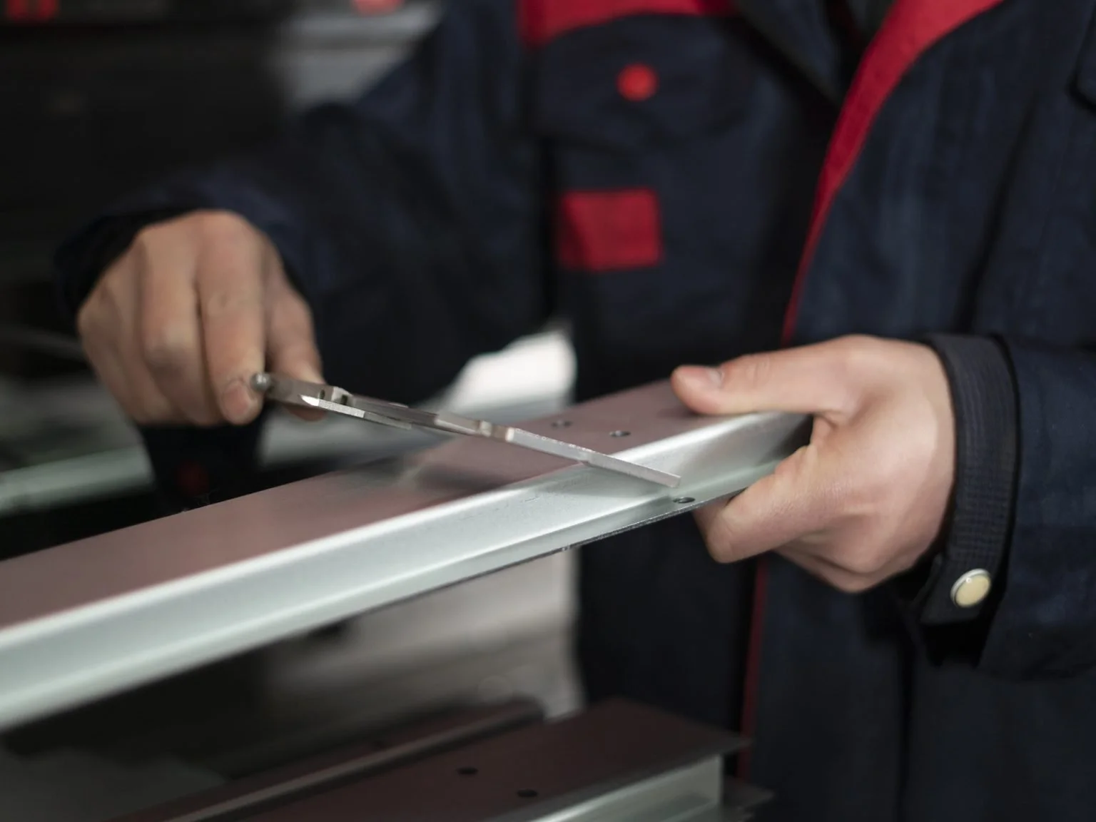 Personne utilisant un pied à coulisse pour mesurer une pièce métallique.