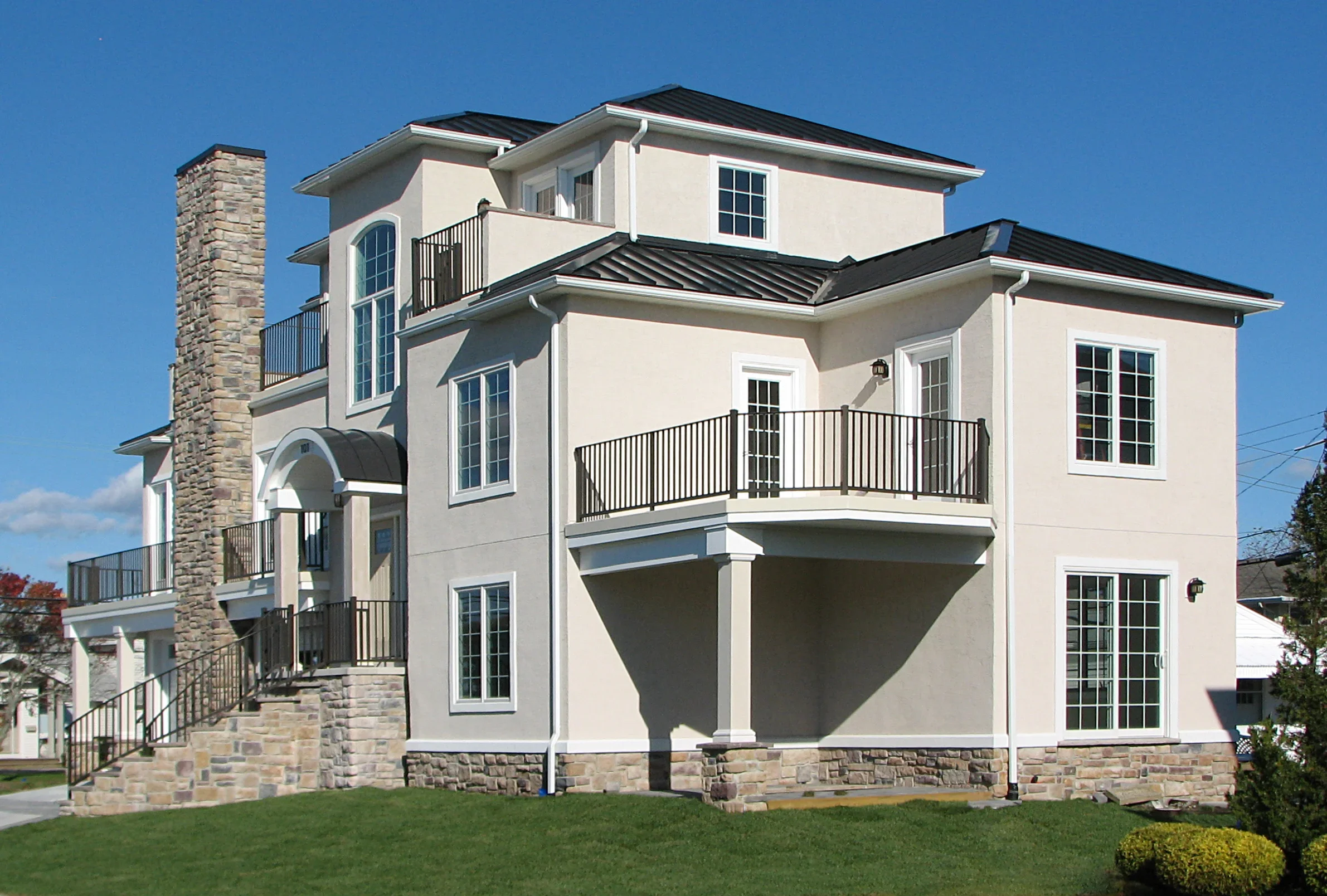 Front right of stucco house stone chimney
