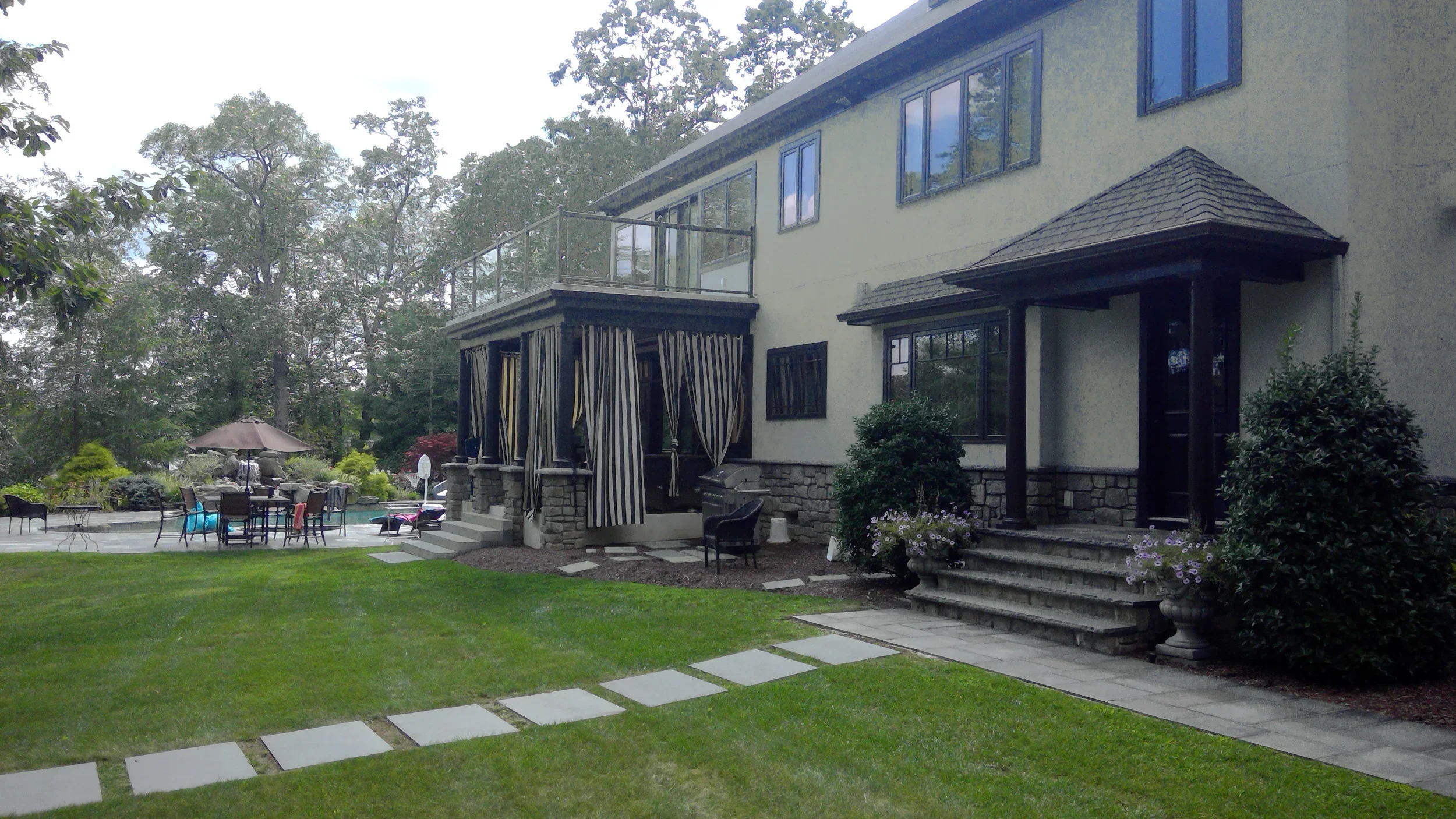 Rear entry and covered porch with second-floor balcony
