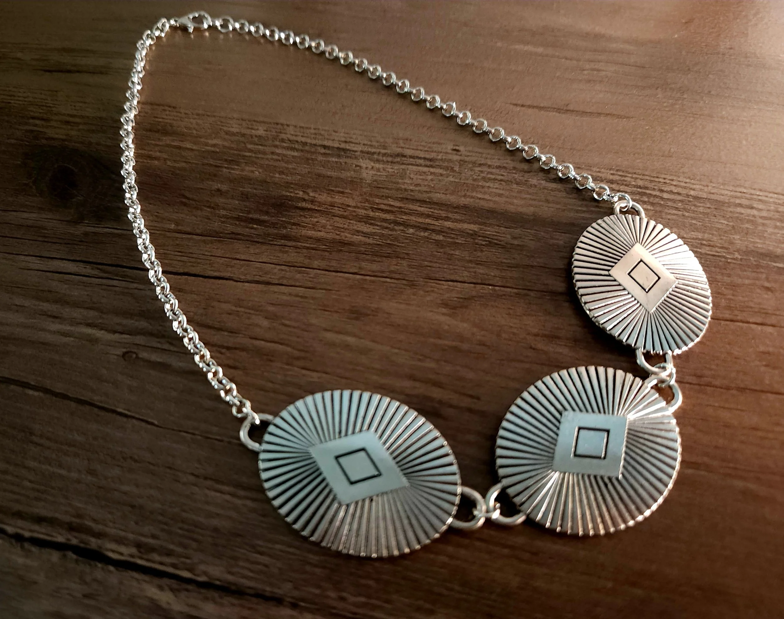 silver concho necklace choker on a wood table