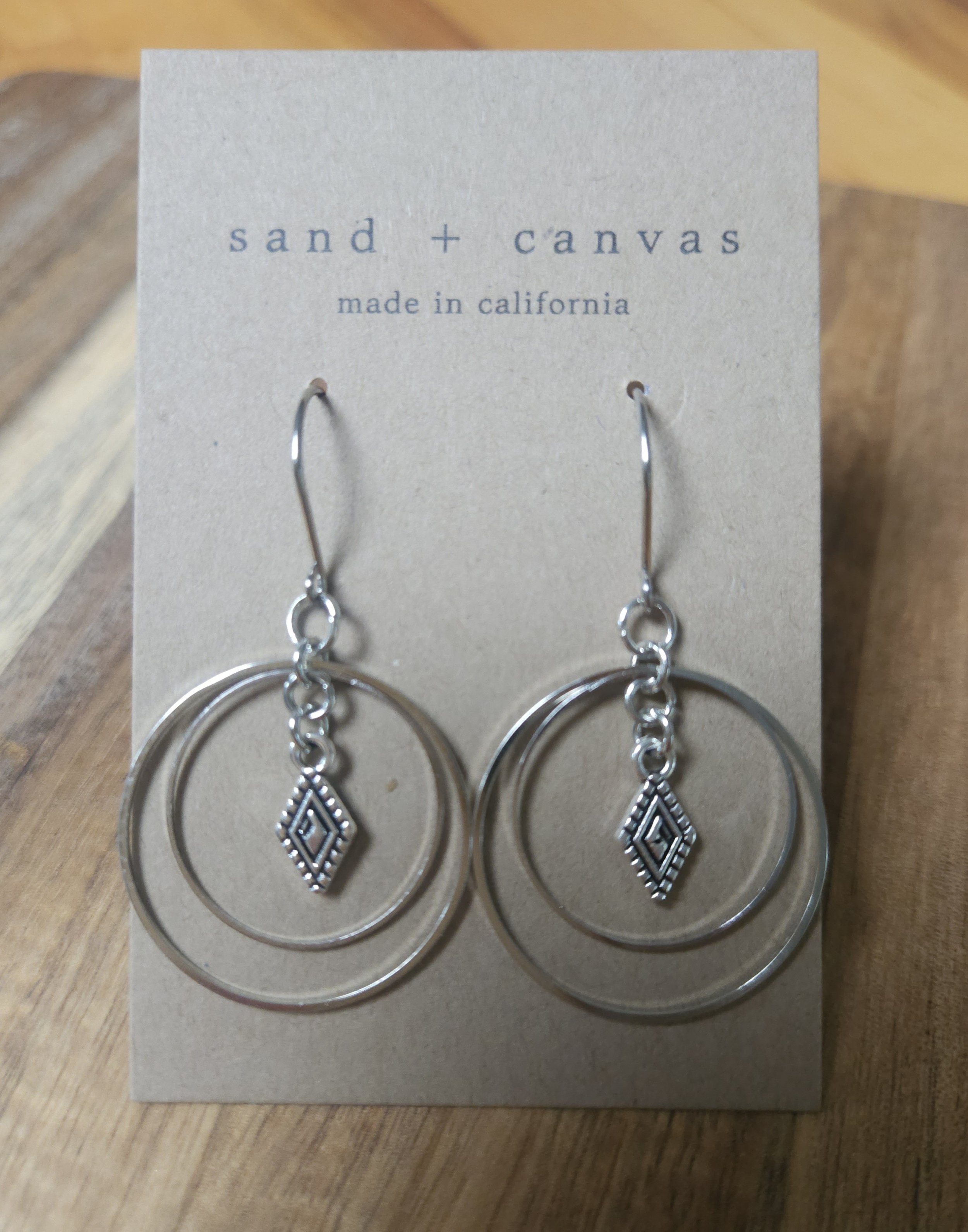 Double hoop earrings that are silver with diamond charm