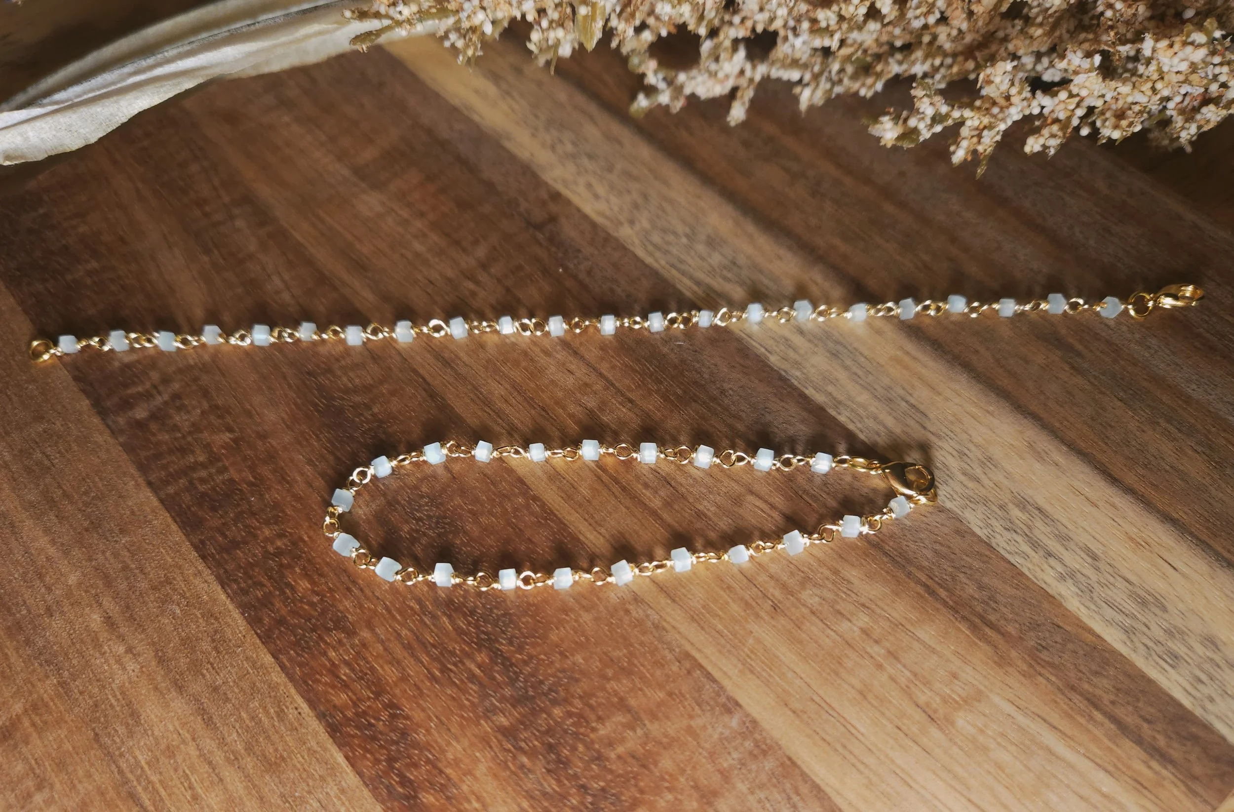 light gold and blue bracelet on a wood table