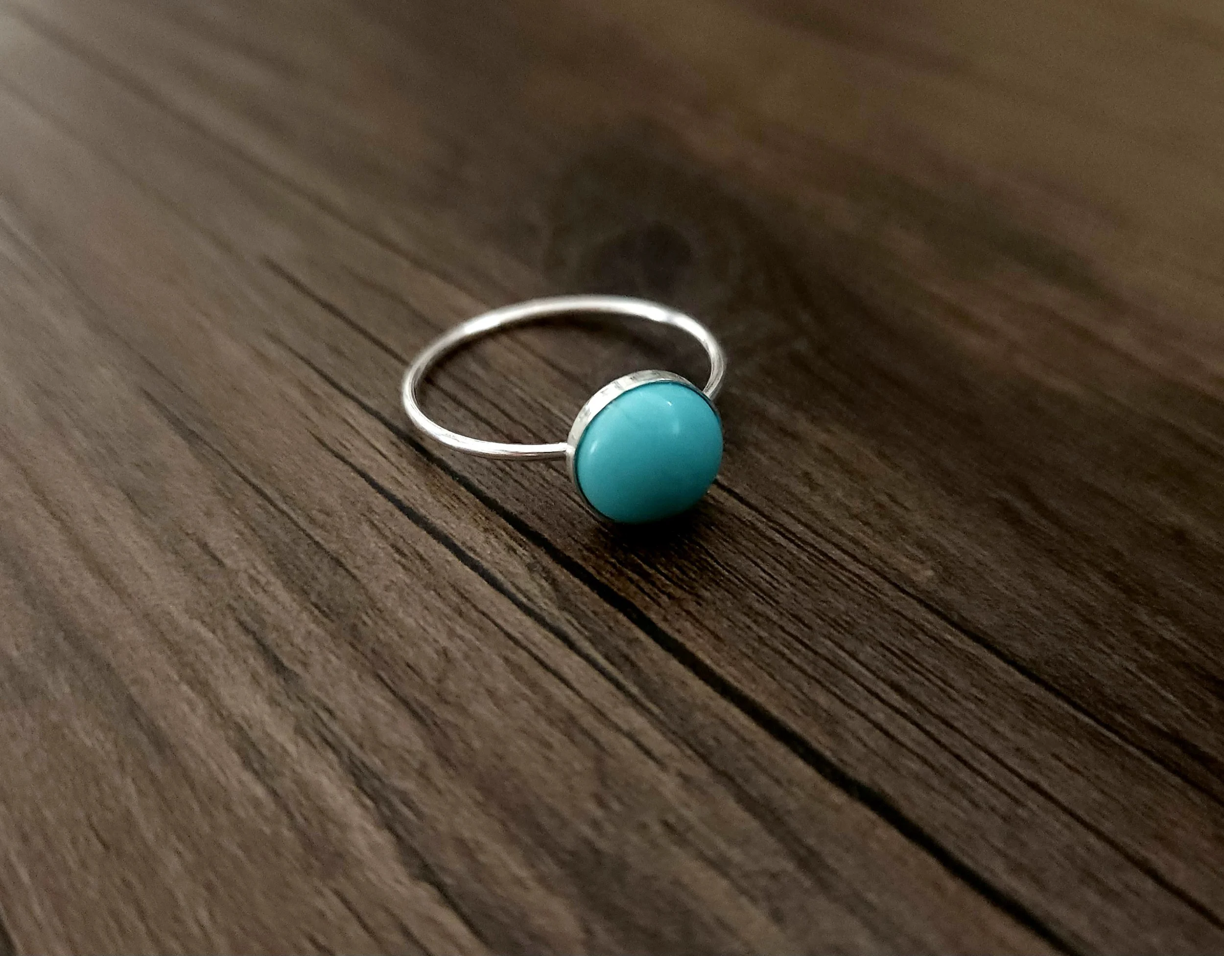 Turquoise and silver ring with round edging sand and canvas