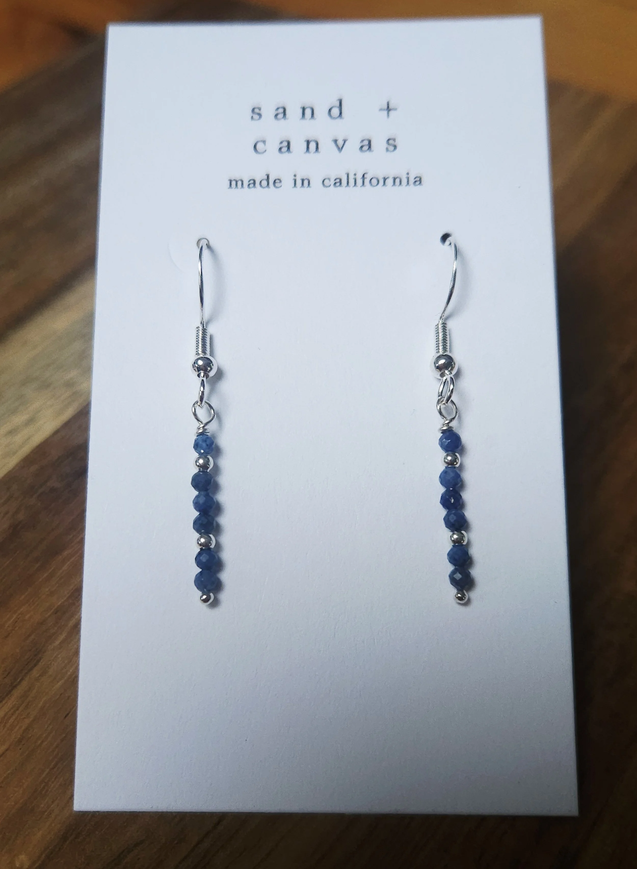 sterling silver earrings with blue sapphire on a table
