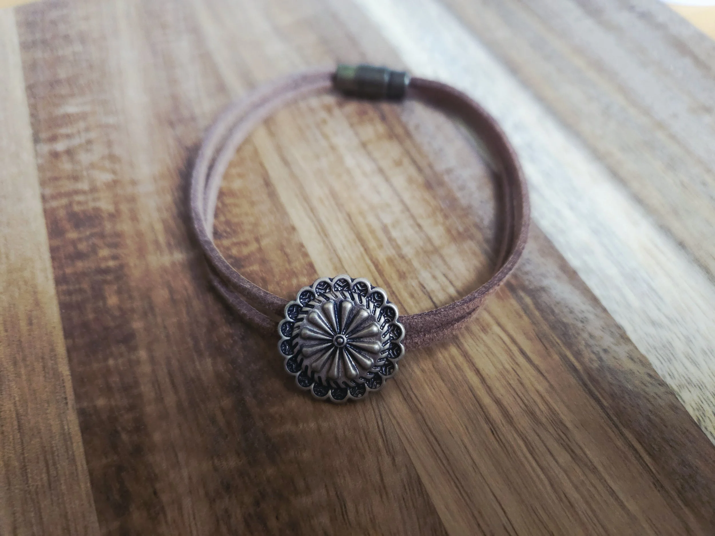 Western concho bracelet on wood background