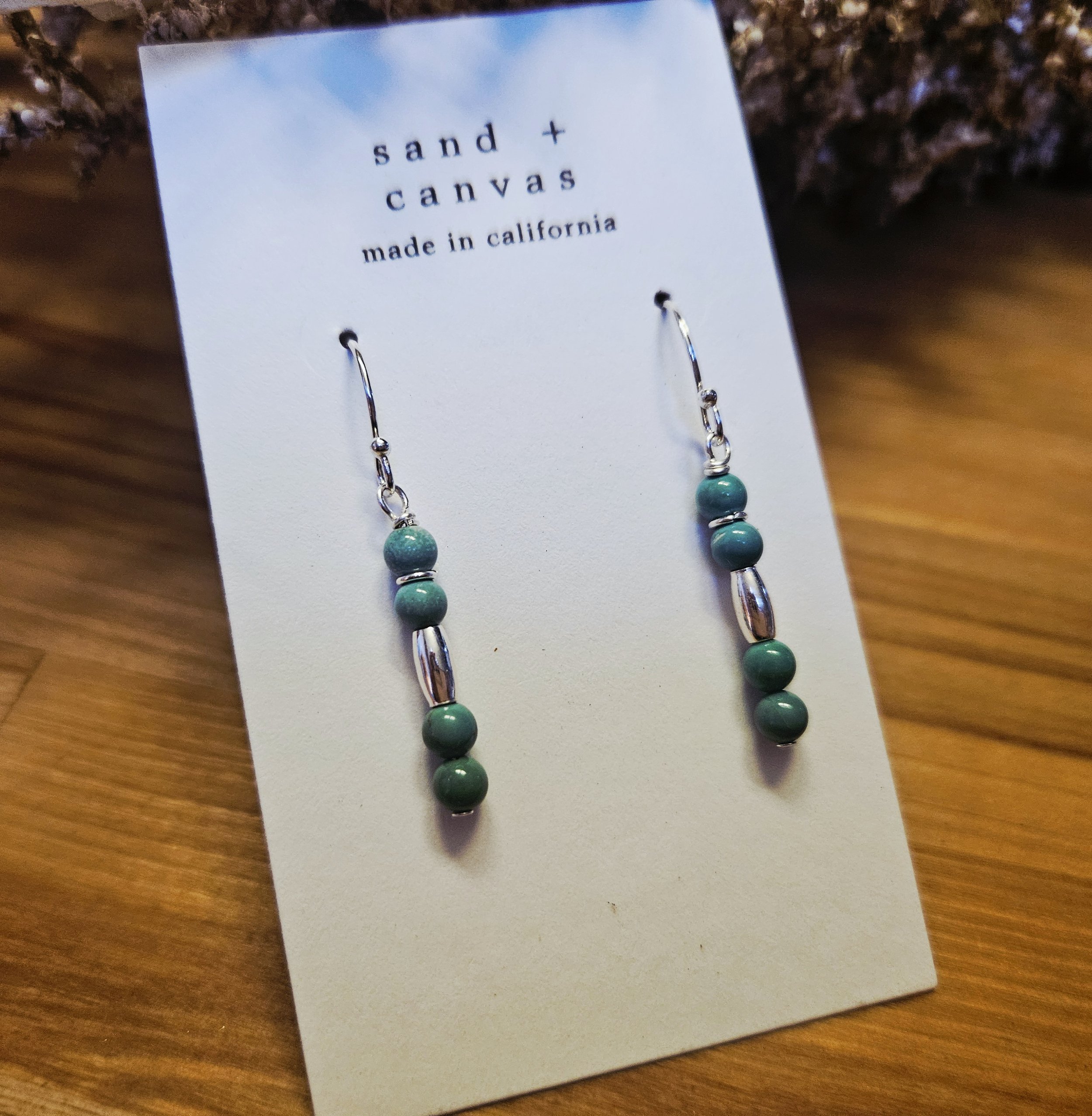 New Mexico turquoise and sterling silver earrings on a wood background