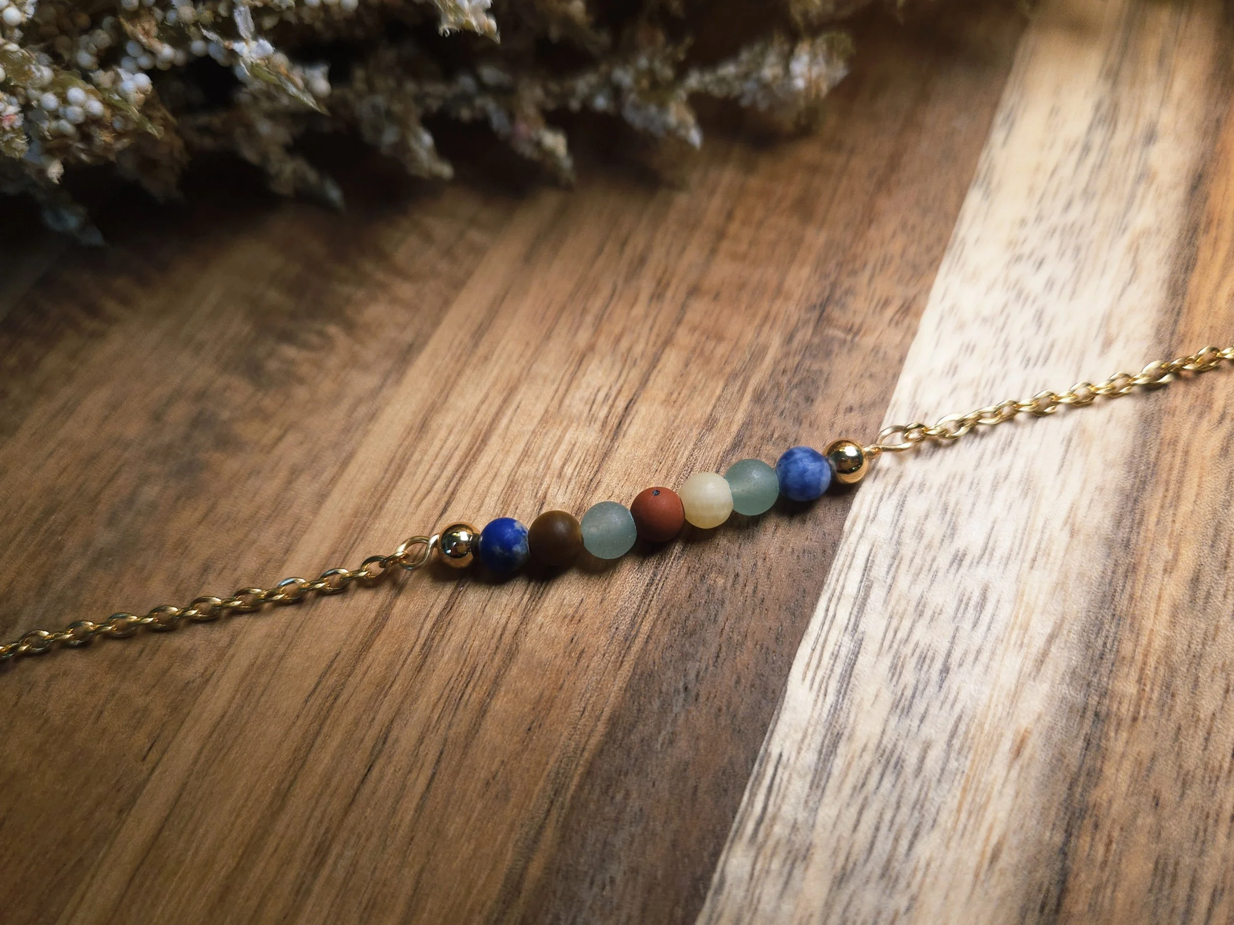 multi colored chakra bracelet on a wood board