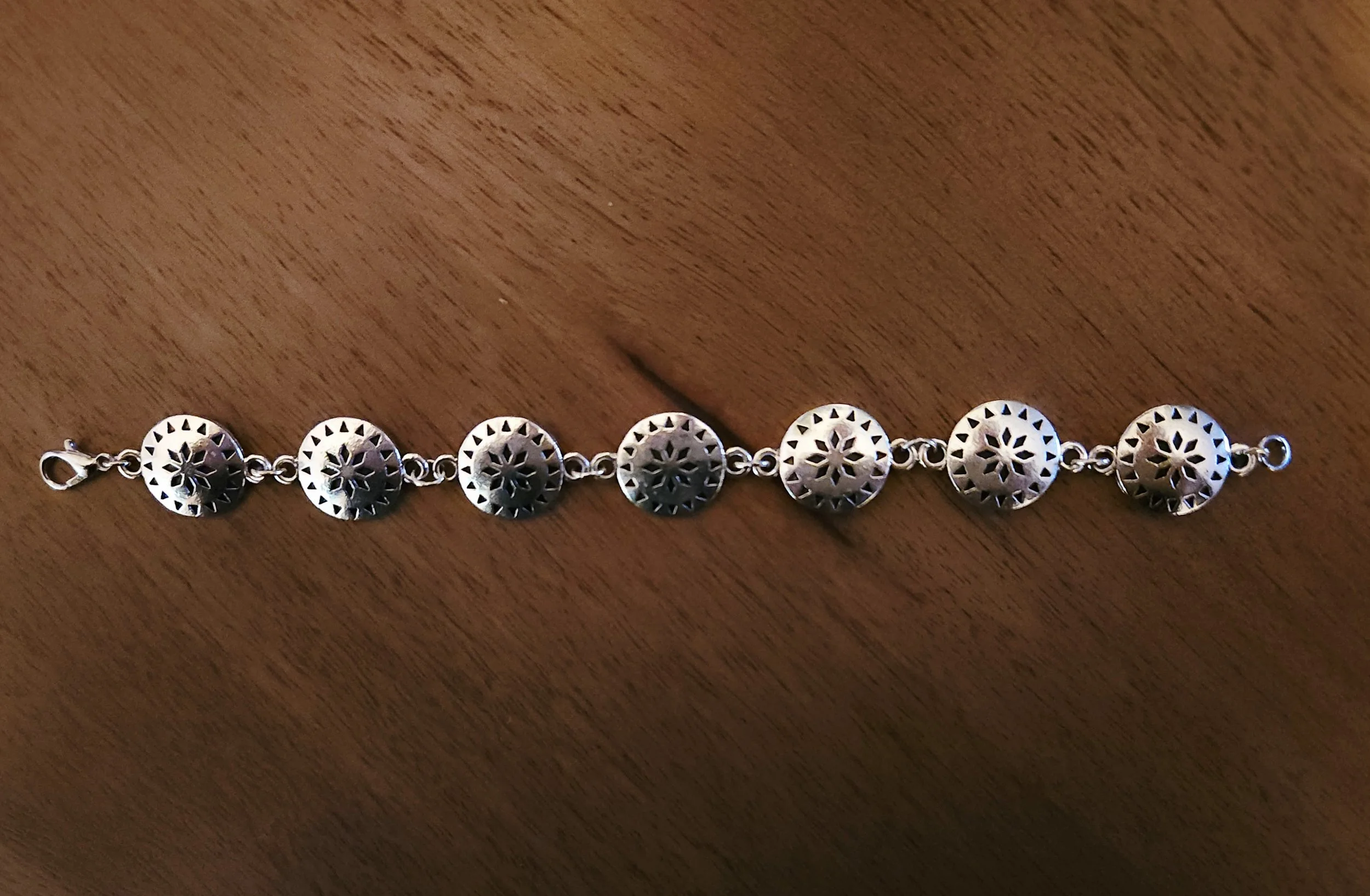 Western-inspired silver concho bracelet with detailed floral pattern