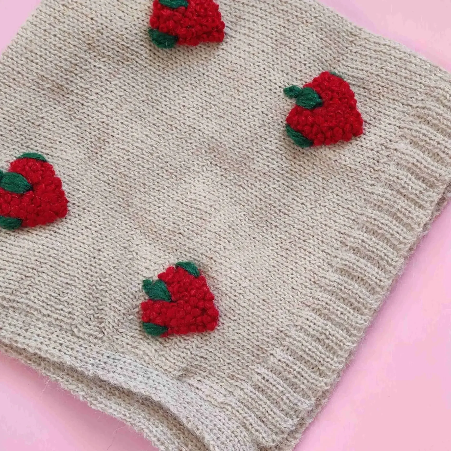 Le bonnet béguin pour bébé en alpaga blanc avec des broderies artisanales de fraises