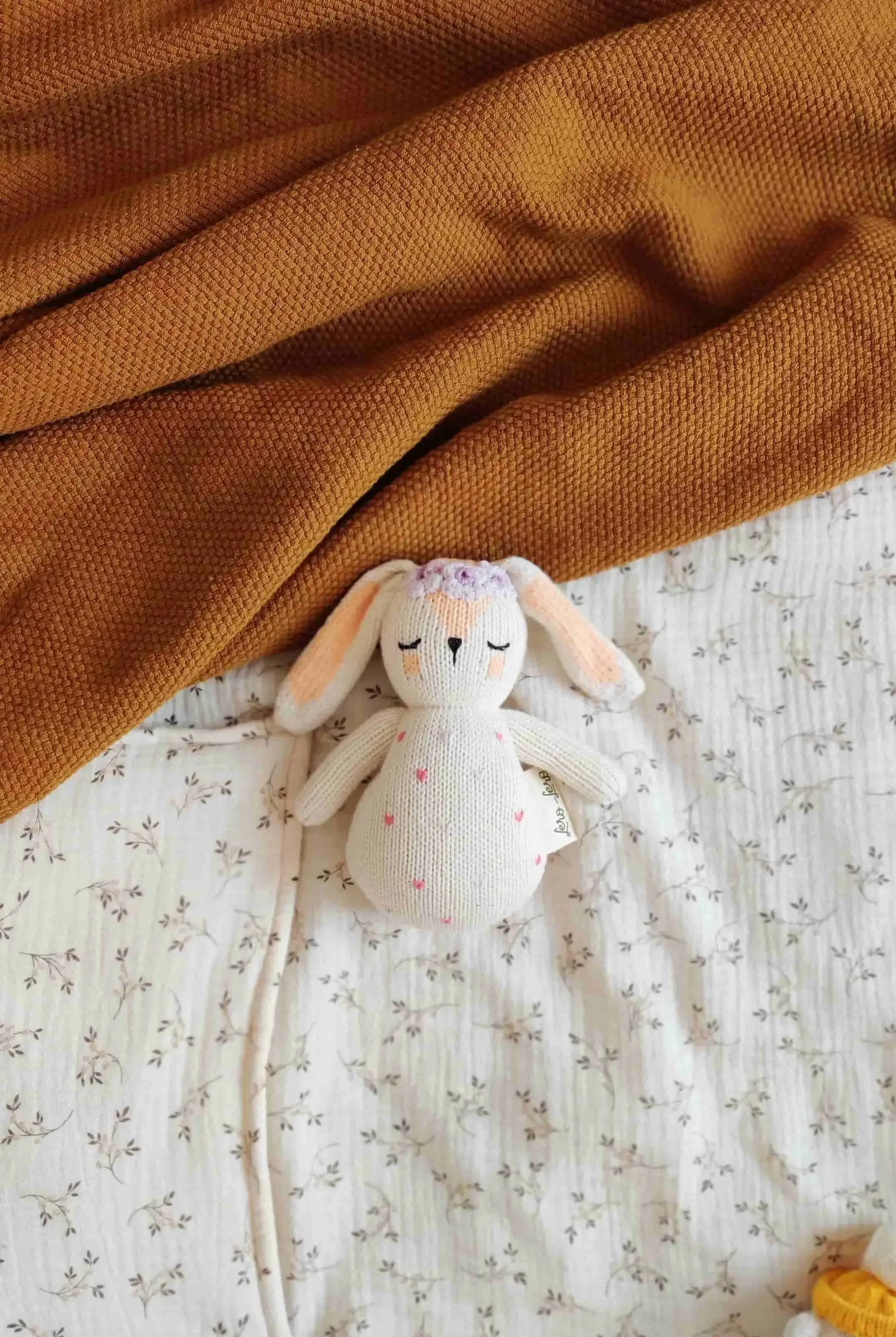 Hochet lapin Qori pour éveiller les nouveau-nés sur un lit