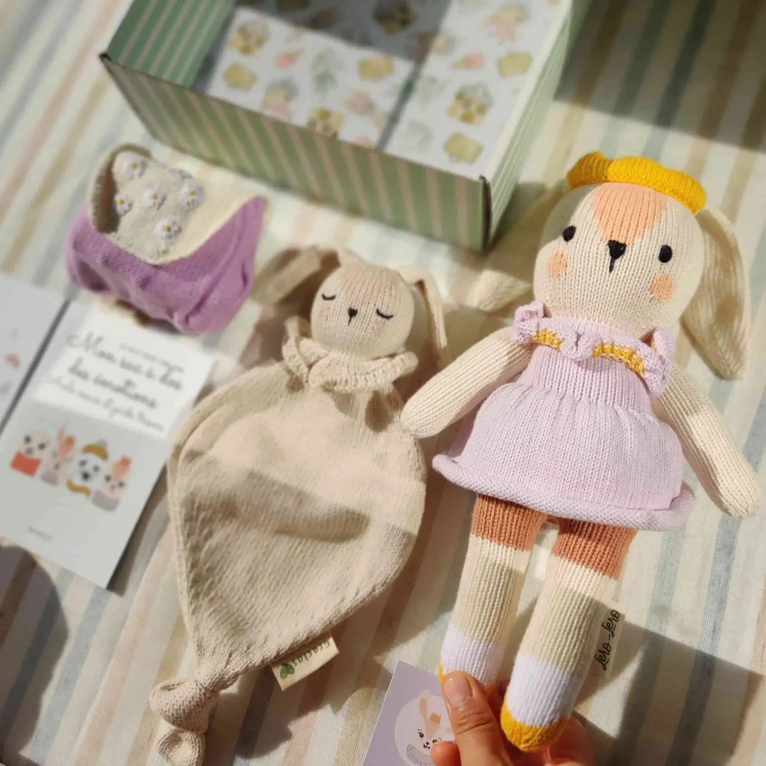 Détail sur la composition du coffret naissance Qori la lapine : peluche Qori, sac à dos des émotions à broderies fleurs et attache-tétine. Tricotés en coton bio.