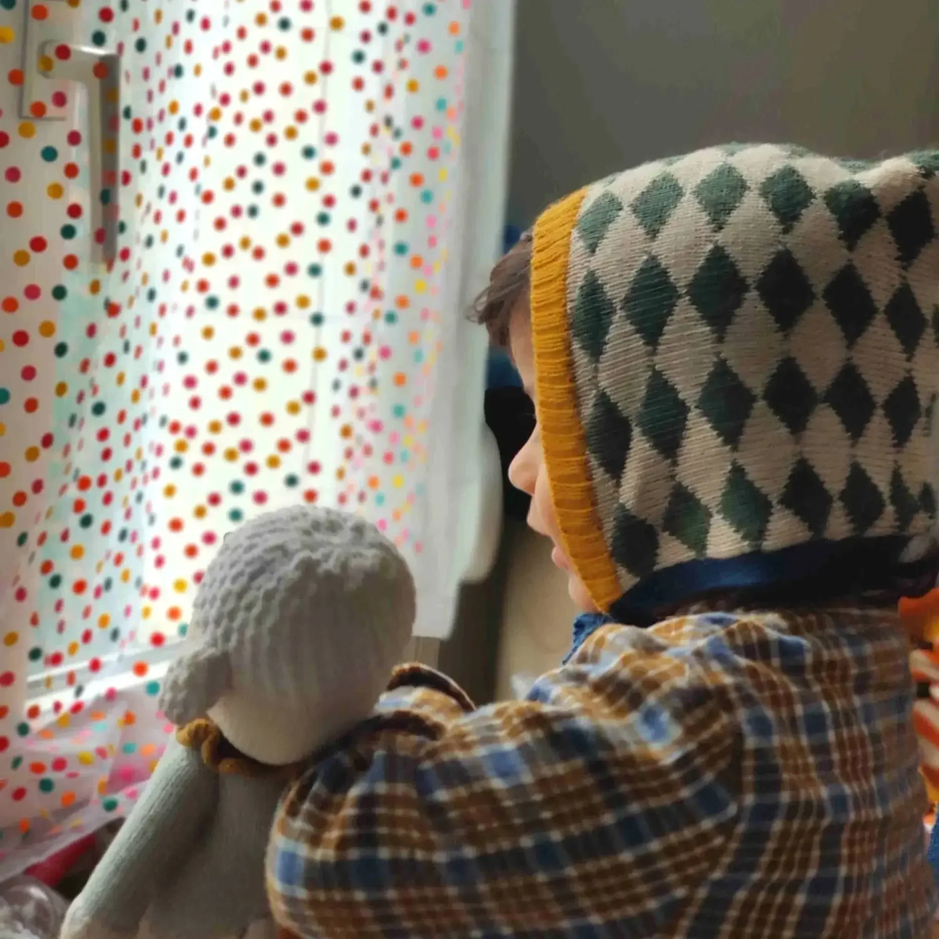 Bébé qui porte un bonnet béguin en alpaga avec motif losanges