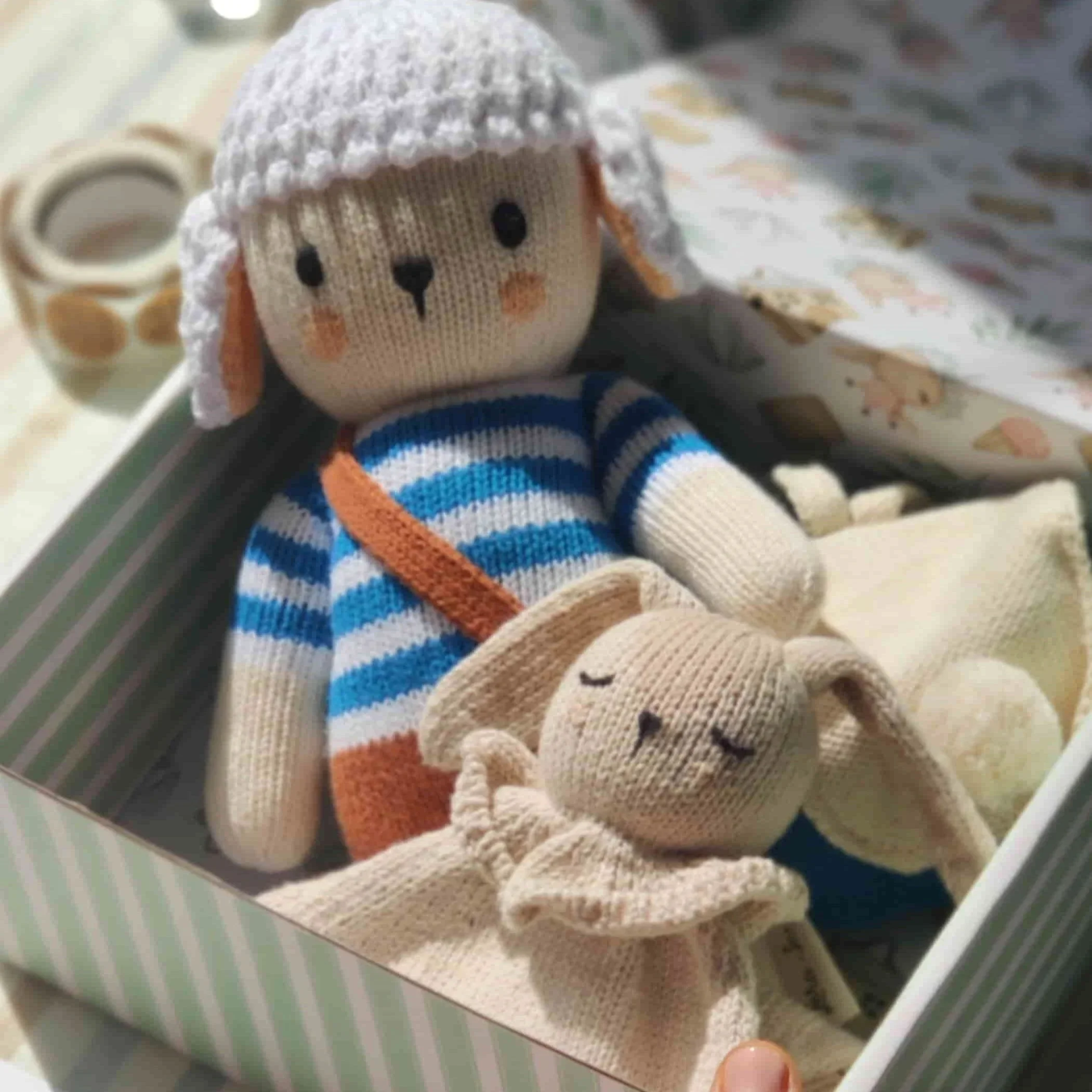 Coffret naissance Nino Marin le Mouton avec la peluche des émotions Nino Marin, son sac à dos des émotions bleu et le doudou attache-tétine dans sa boîte cadeau