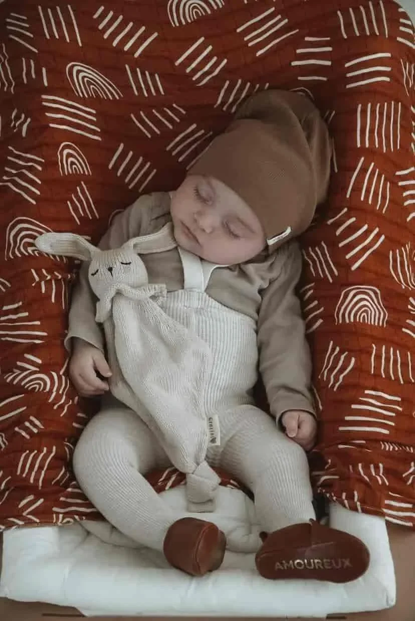 Bébé qui dort avec son doudou lapin attache-tétine blanc