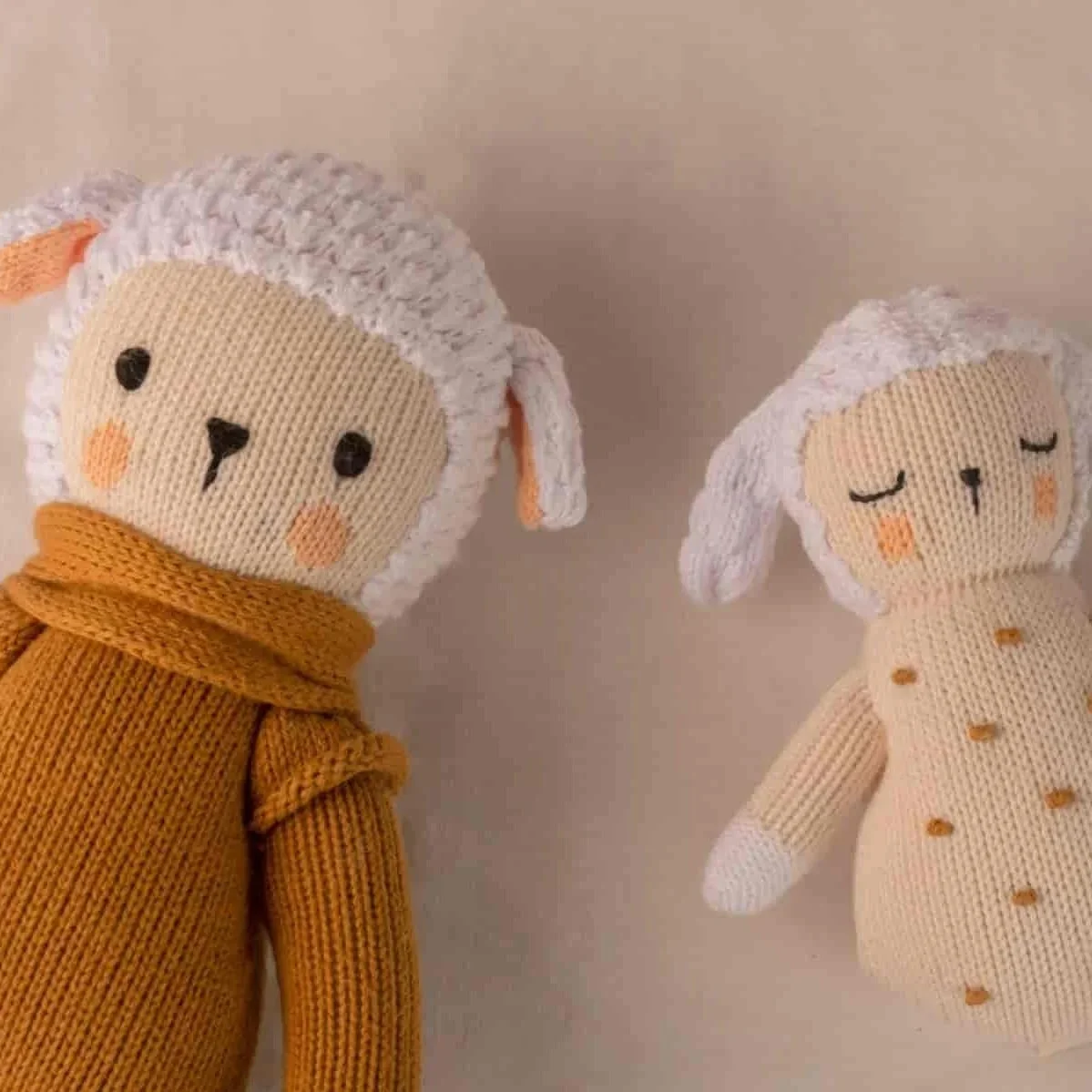 Peluche Nino Caramel le Mouton à côté du hochet Nino