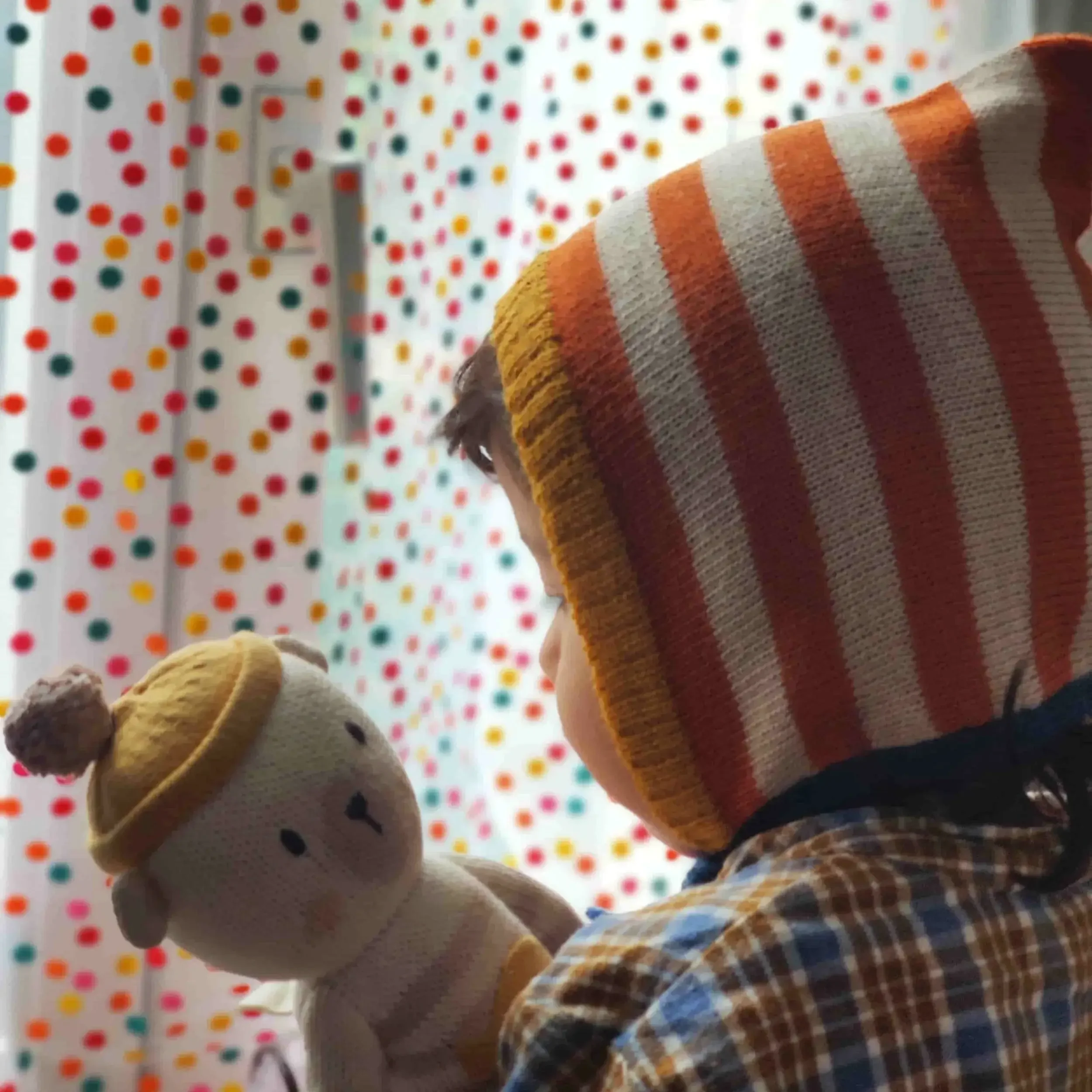 Bébé qui porte un bonnet béguin en alpaga avec motif rayures