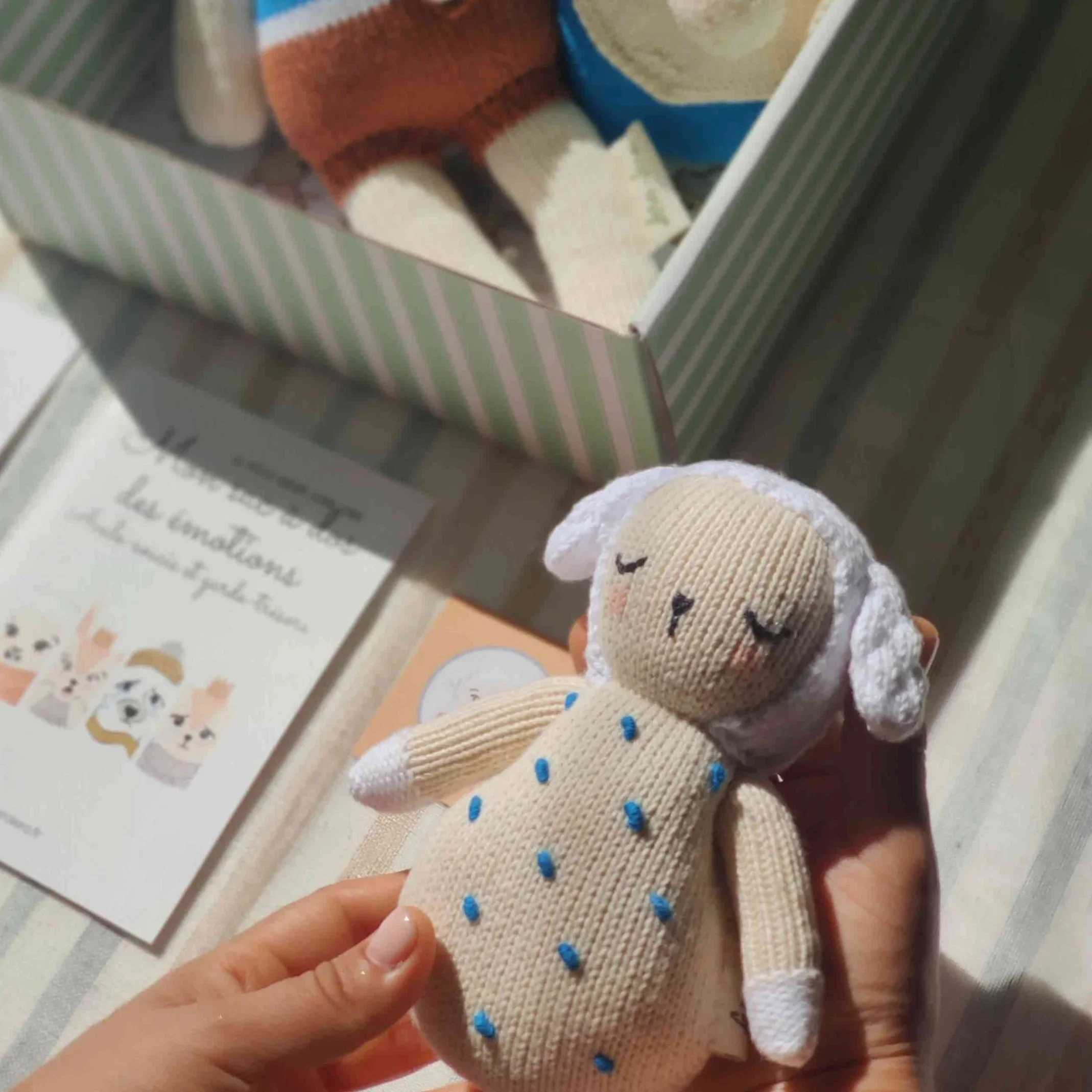 Hochet mouton Nino avec broderies bleues pour bébé tricoté en coton bio avec grelot