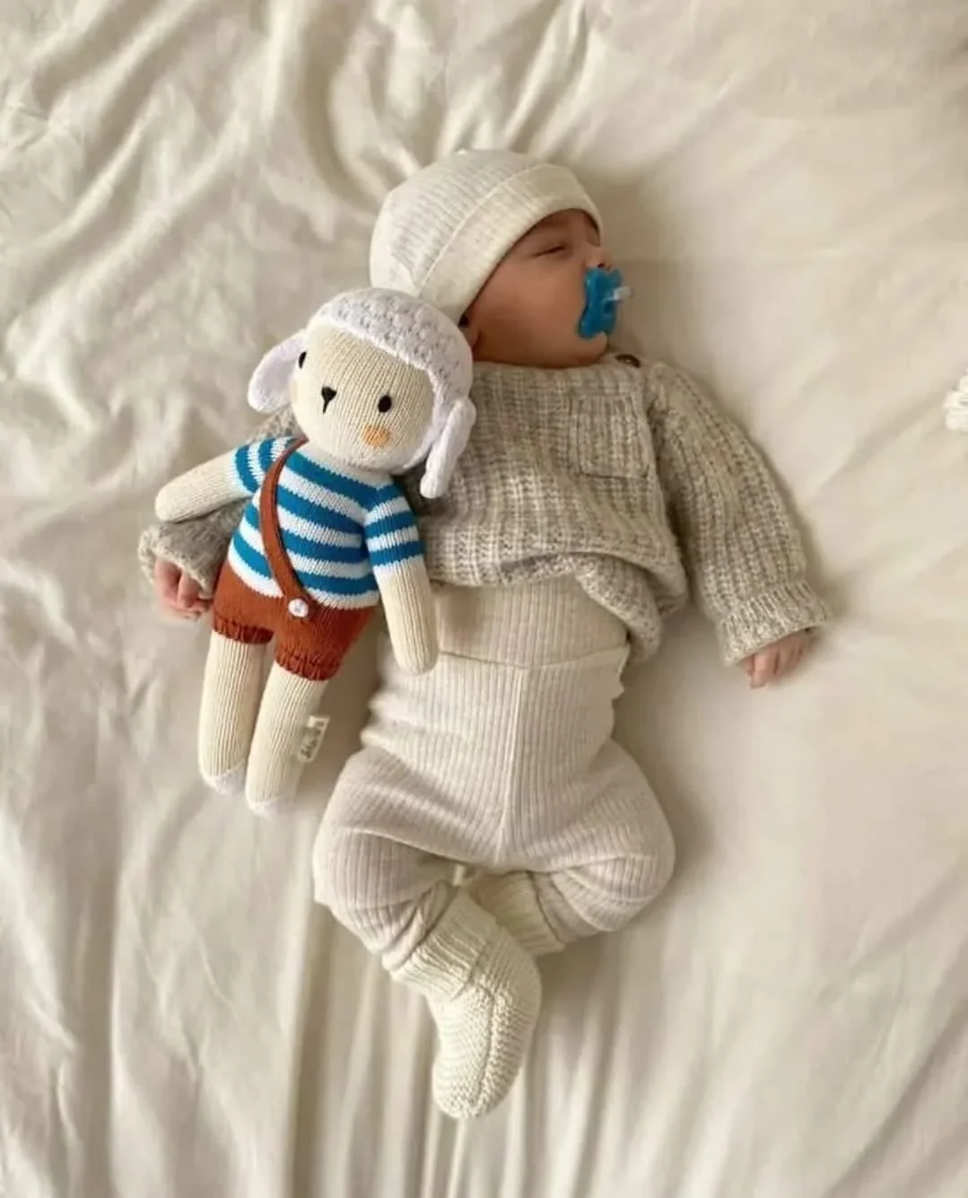 Le doudou mouton Nino Marin avec un bébé qui dort