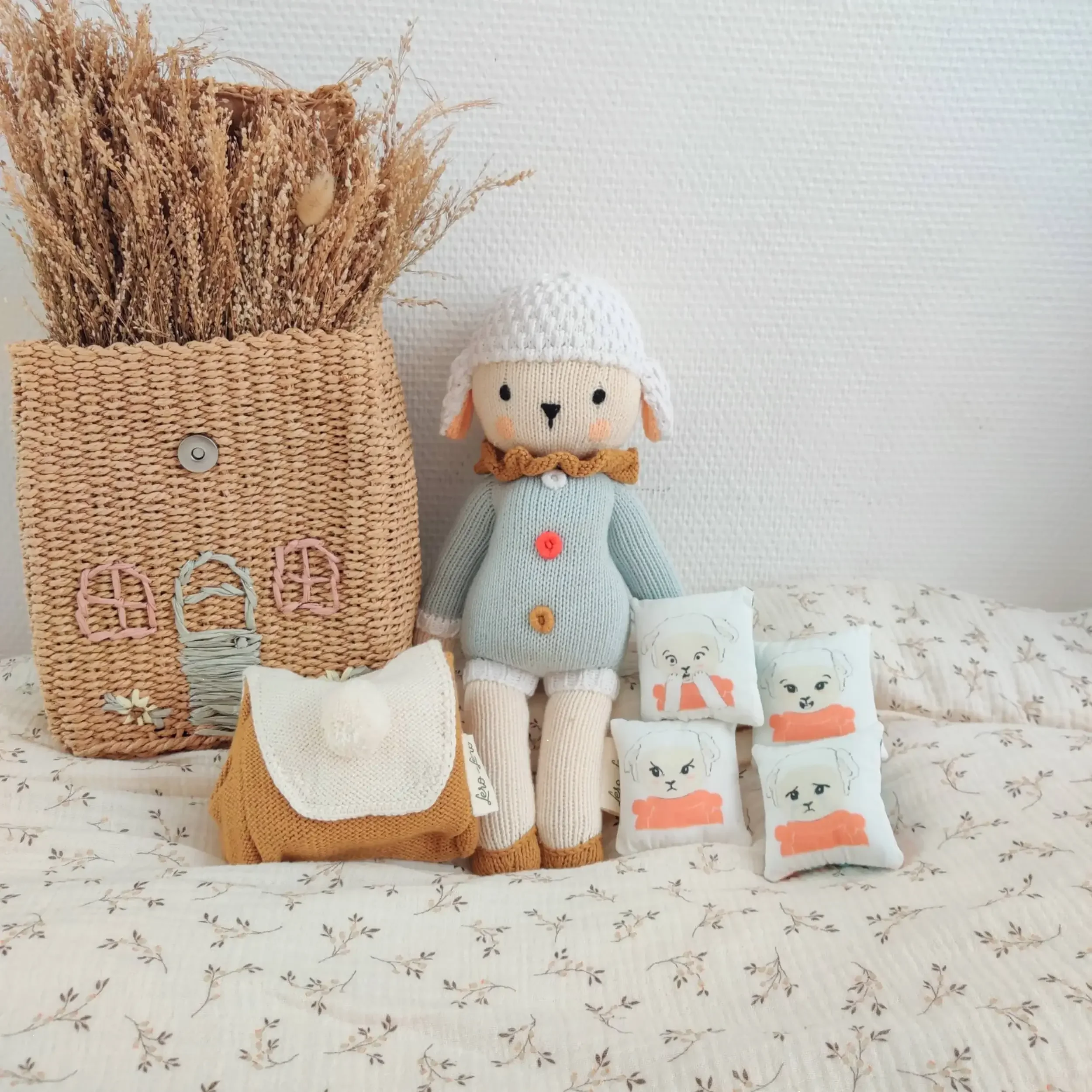 Peluche Nino Rainbow le Mouton assis à côte de son sac à dos des émotions, tricotés artisanalement en coton bio