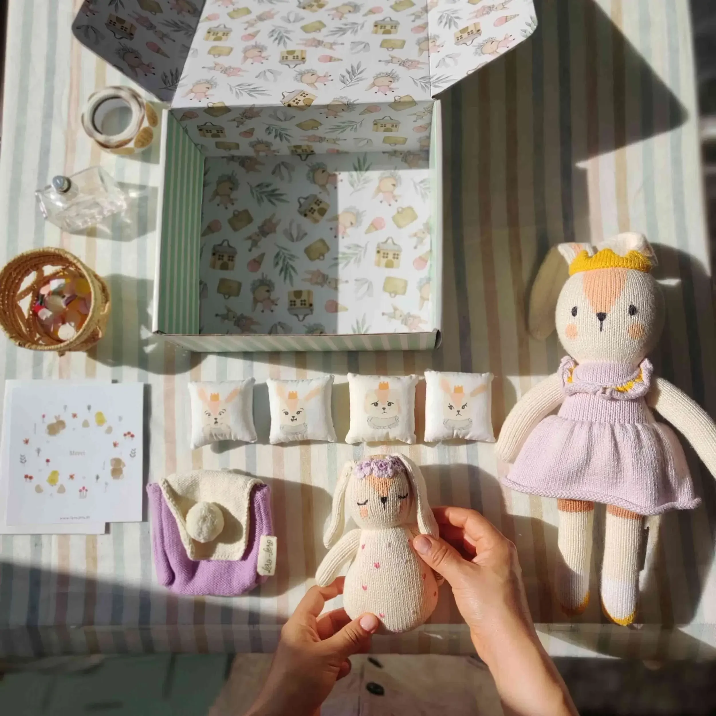 Vue du dessus du coffret naissance avec la peluche des émotions Qori, son sac à dos à pompon et le hochet