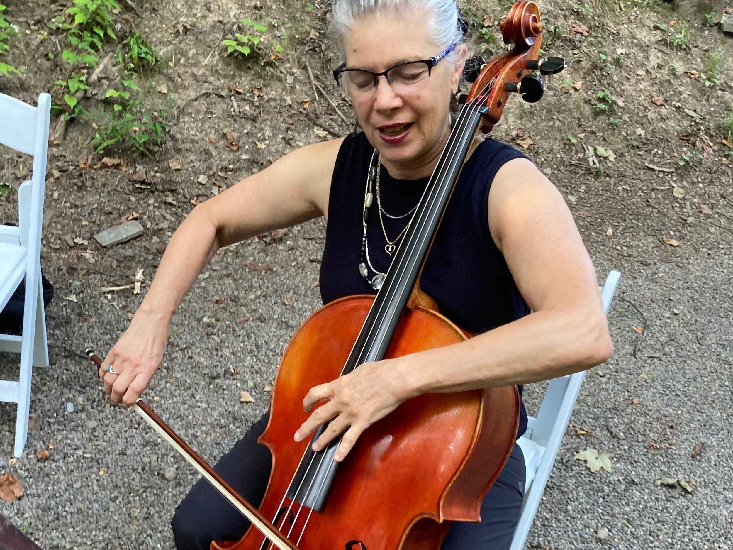 Sera plays a high note on her cello, out in the woods