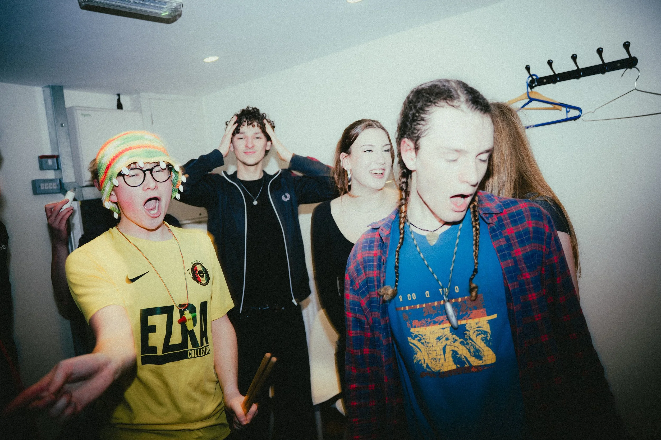 Group of young people at a party or gathering with surprised and energetic expressions.