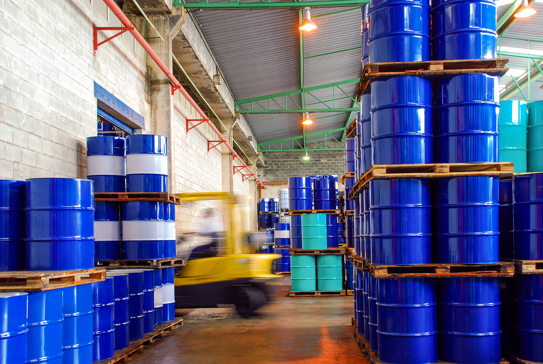lubricants supplier with warehouse full of blue oil barrels.png