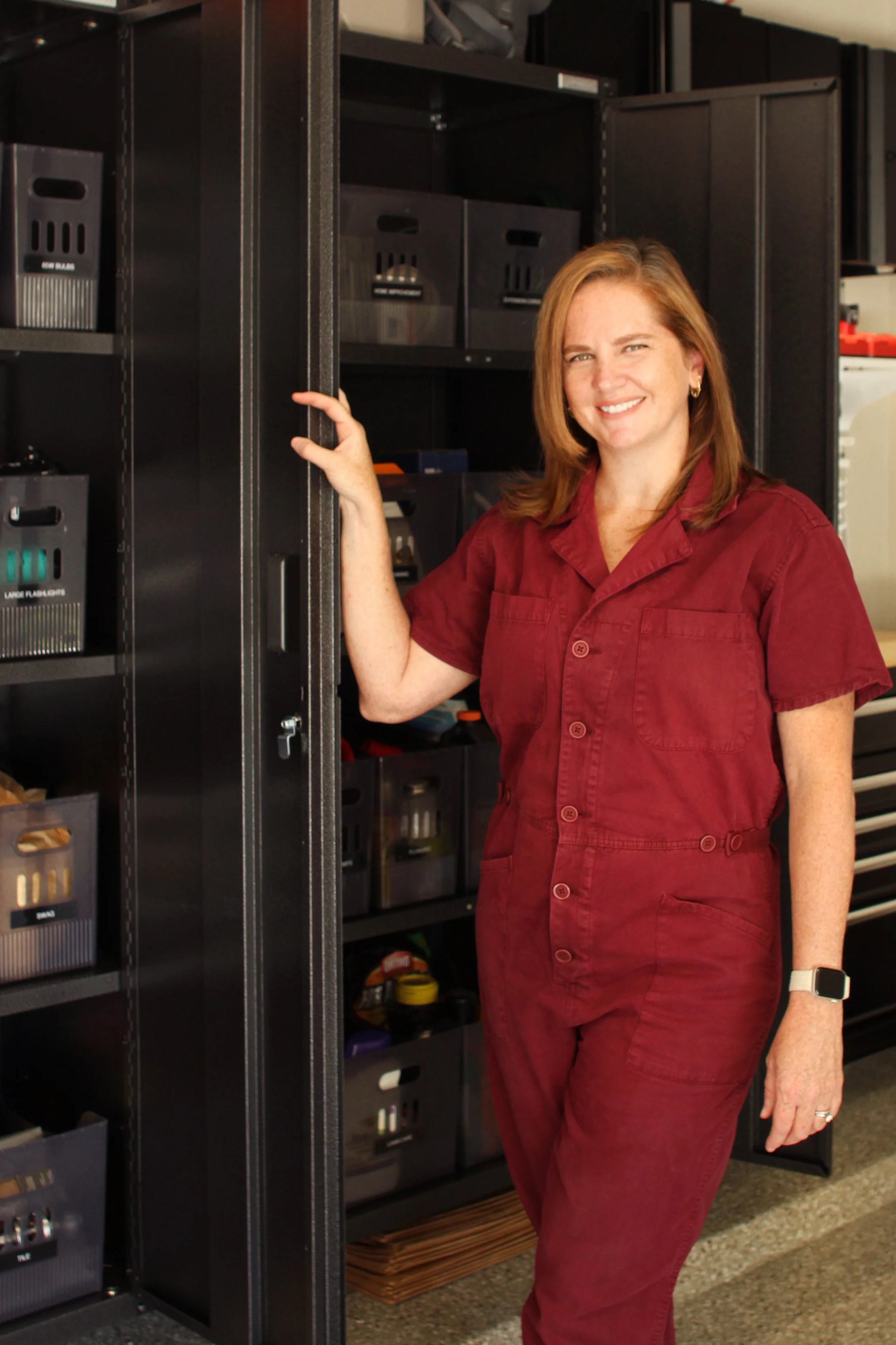 Erin Vyhanek, professional home organizer in Austin, Texas, standing in an organized garage storage system created by Live Organized by Erin
