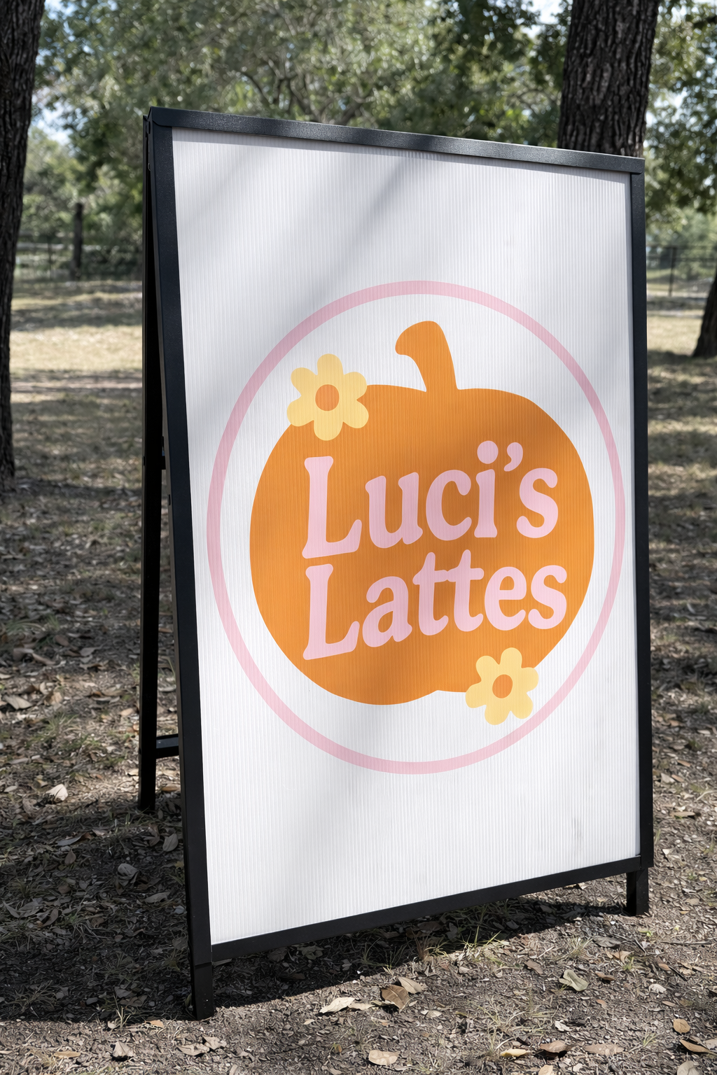 Outdoor signboard advertising Luci's Lattes with a pumpkin and flower design.