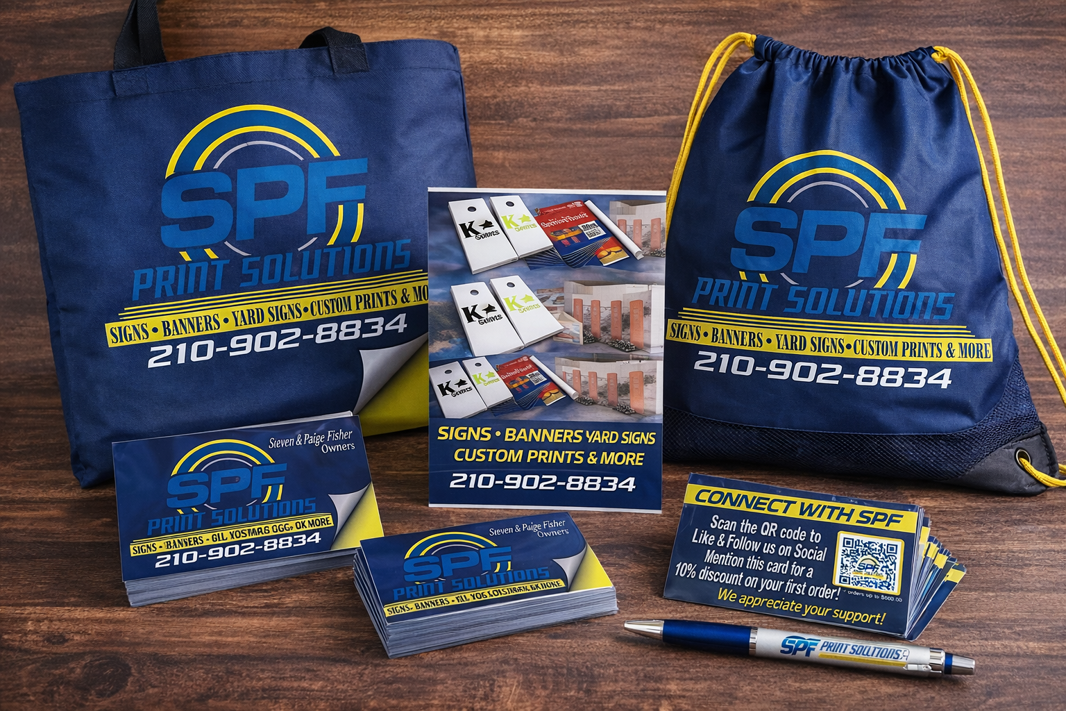 Promotional display for SPF Print Solutions featuring branded tote bags, business cards, flyers, and a pen, all with the company's logo and contact information.