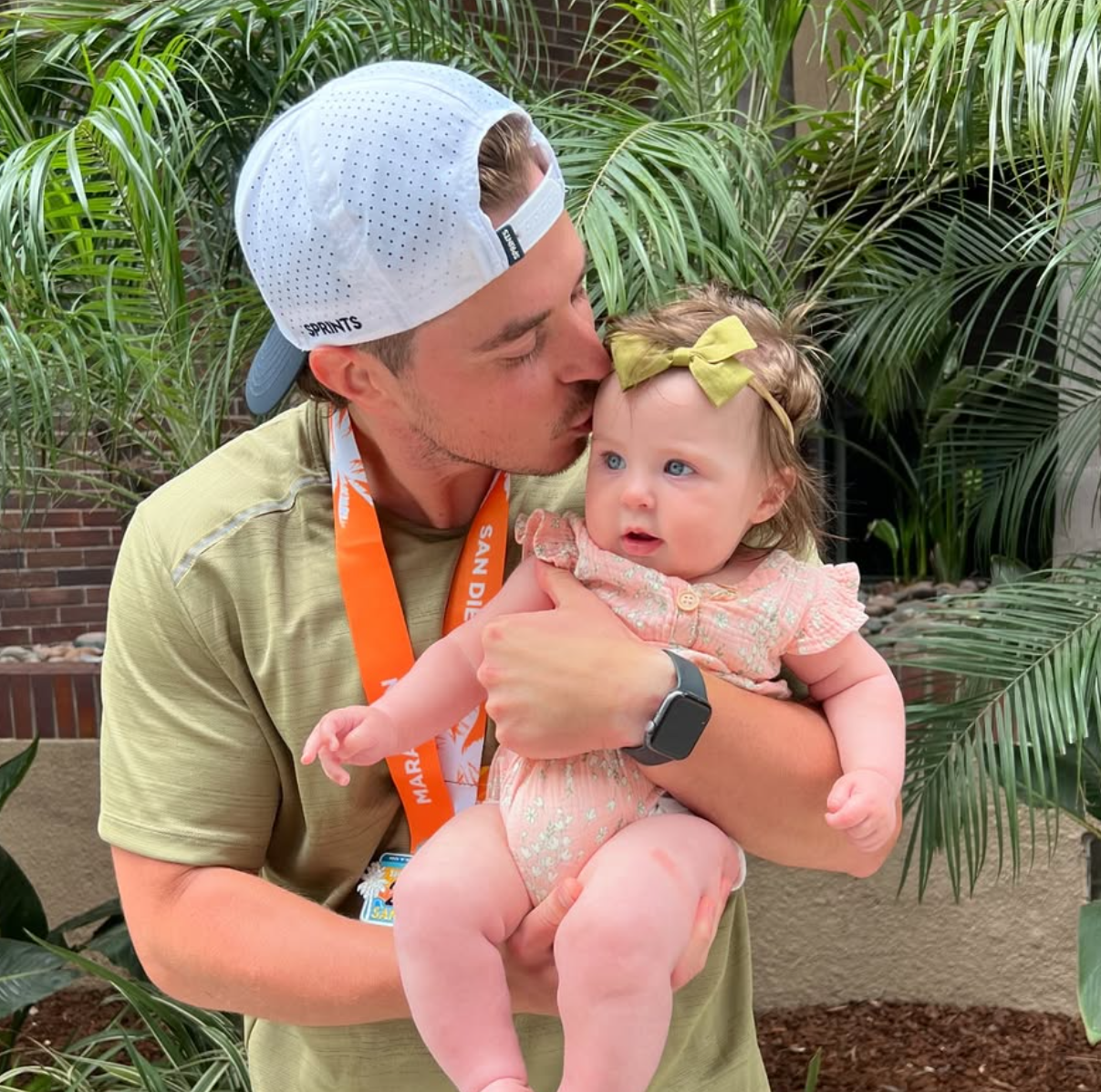 Jake Dellen holding his daughter outdoors, showing his role as a dedicated father and family man