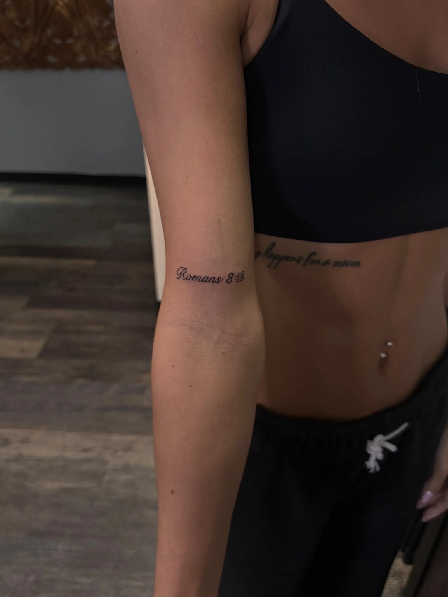 Minimalist fine-line tattoo on a person's upper arm.