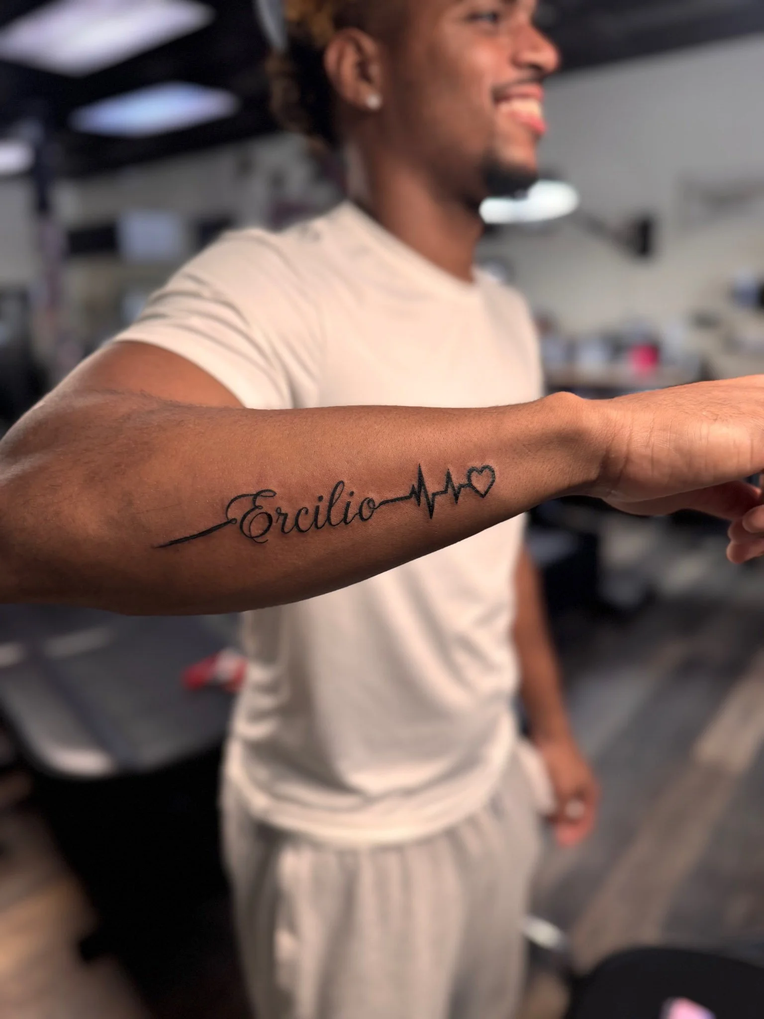 Script inner arm tattoo on a person facing forward