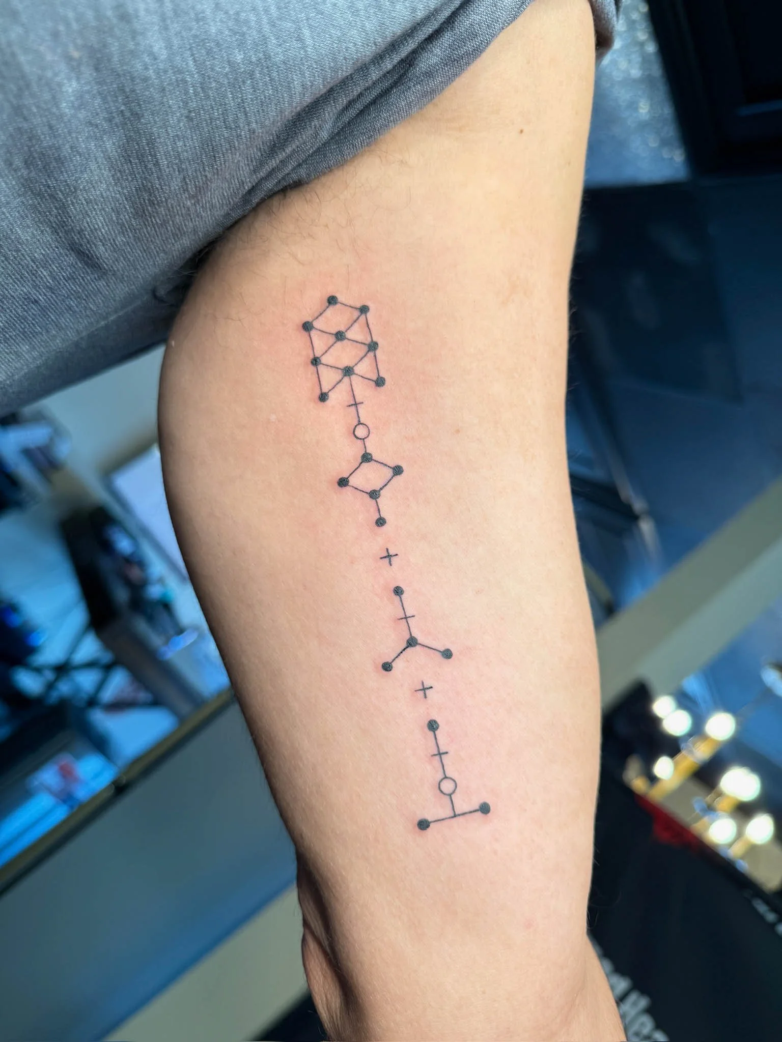 Tattoo of the chemical structure of dopamine on a person's arm.