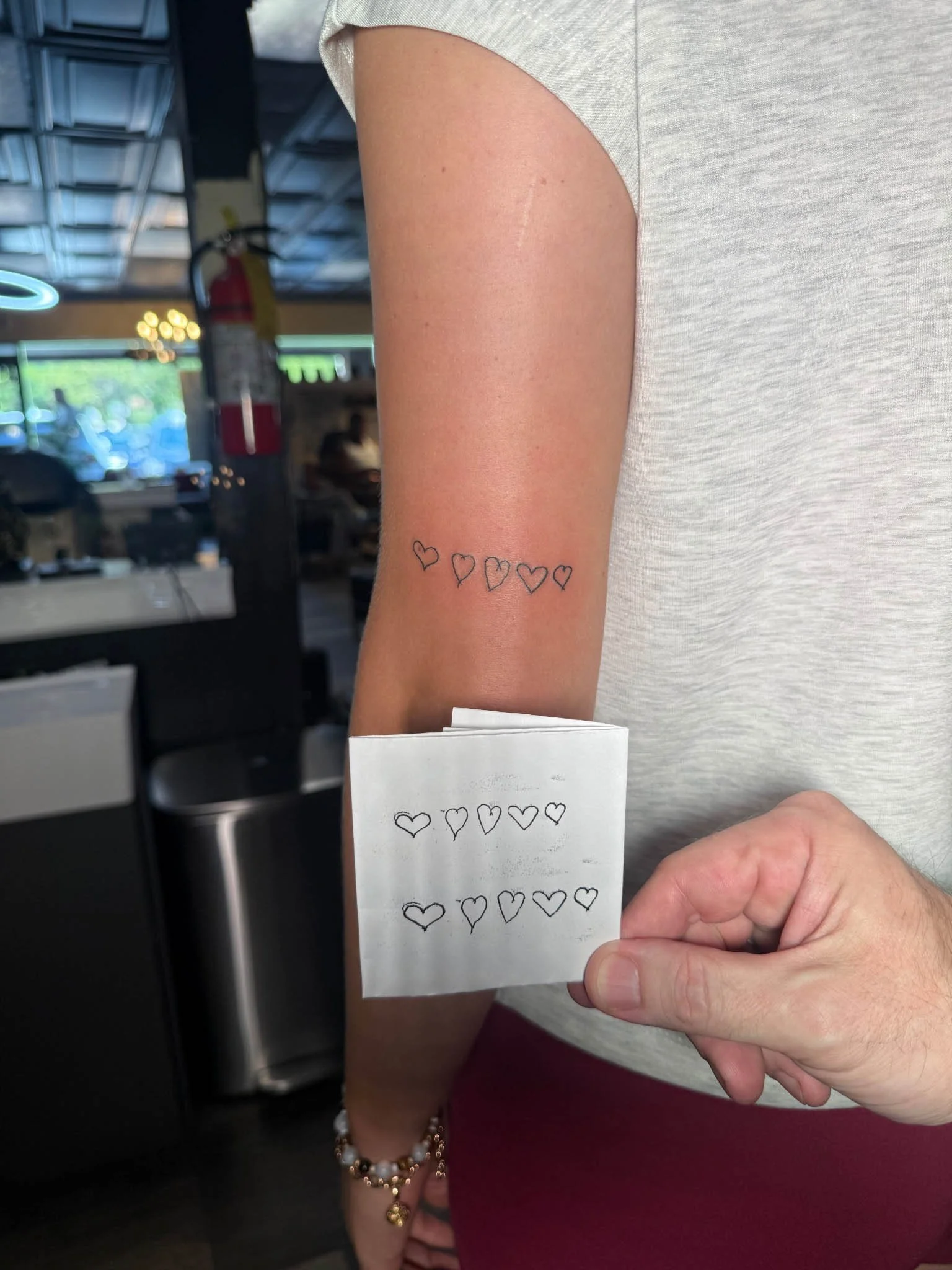 Fineline arm tattoo shown next to its paper stencil outline