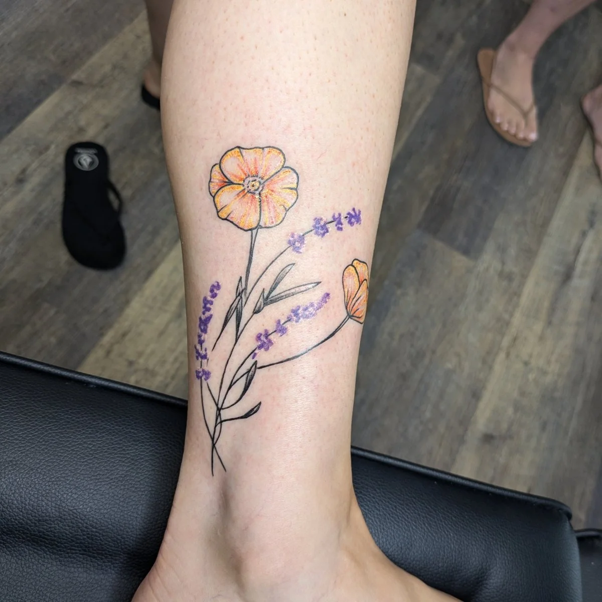 yellow flower tattoo in ankle.jpg