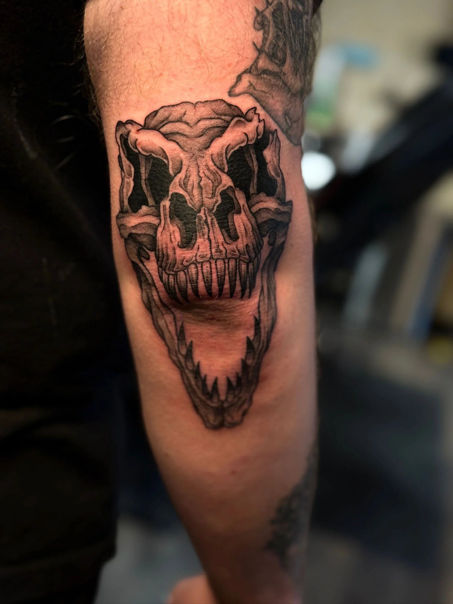 Tattoo of a stylized skull on an arm.