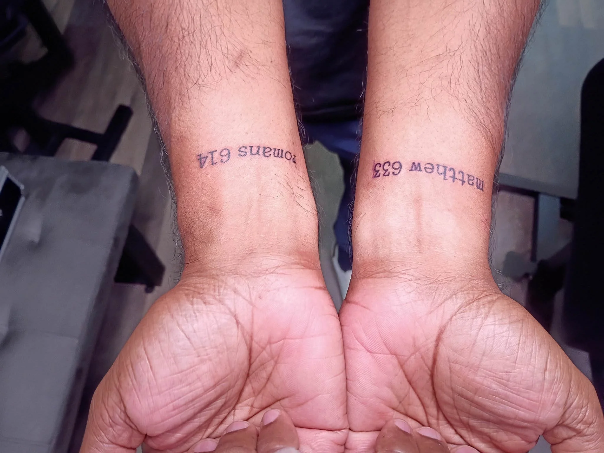 Pair of wrists side-by-side displaying matching handwritten text tattoos
