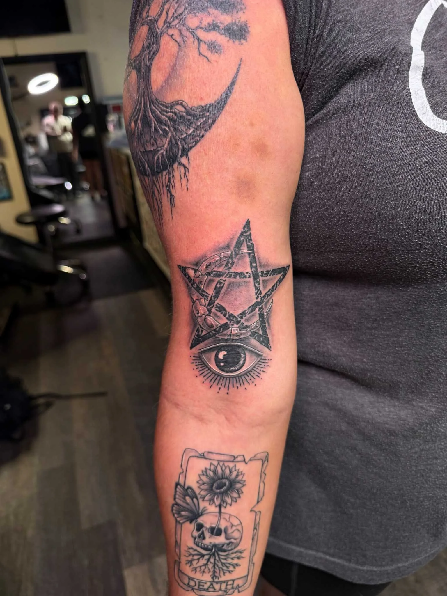 Black and gray illustrative tattoo on an arm.