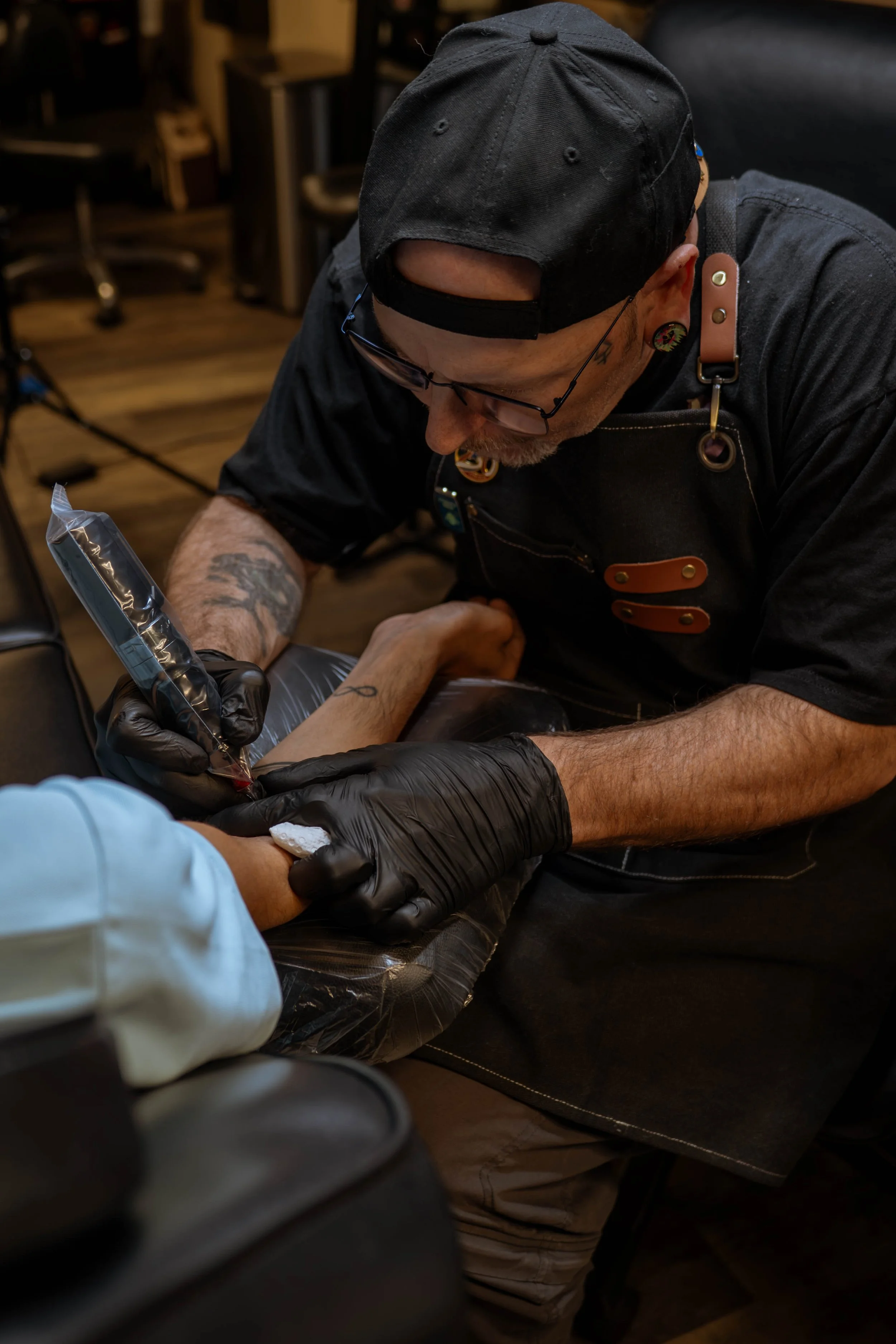 BHT tattoo artist doing an arm tattoo