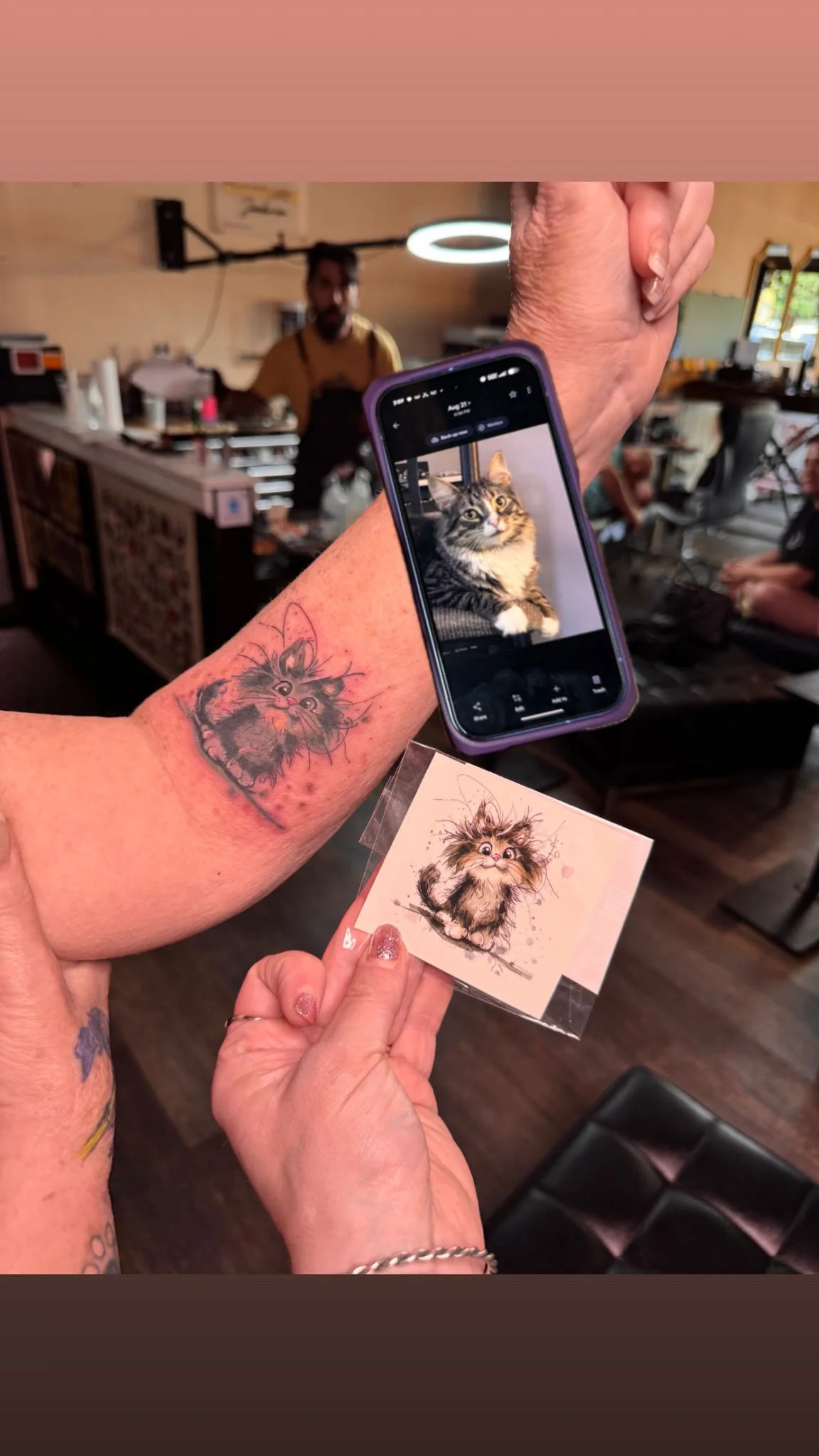 Forearm tattoo shown alongside a smartphone displaying the digital design photo.
