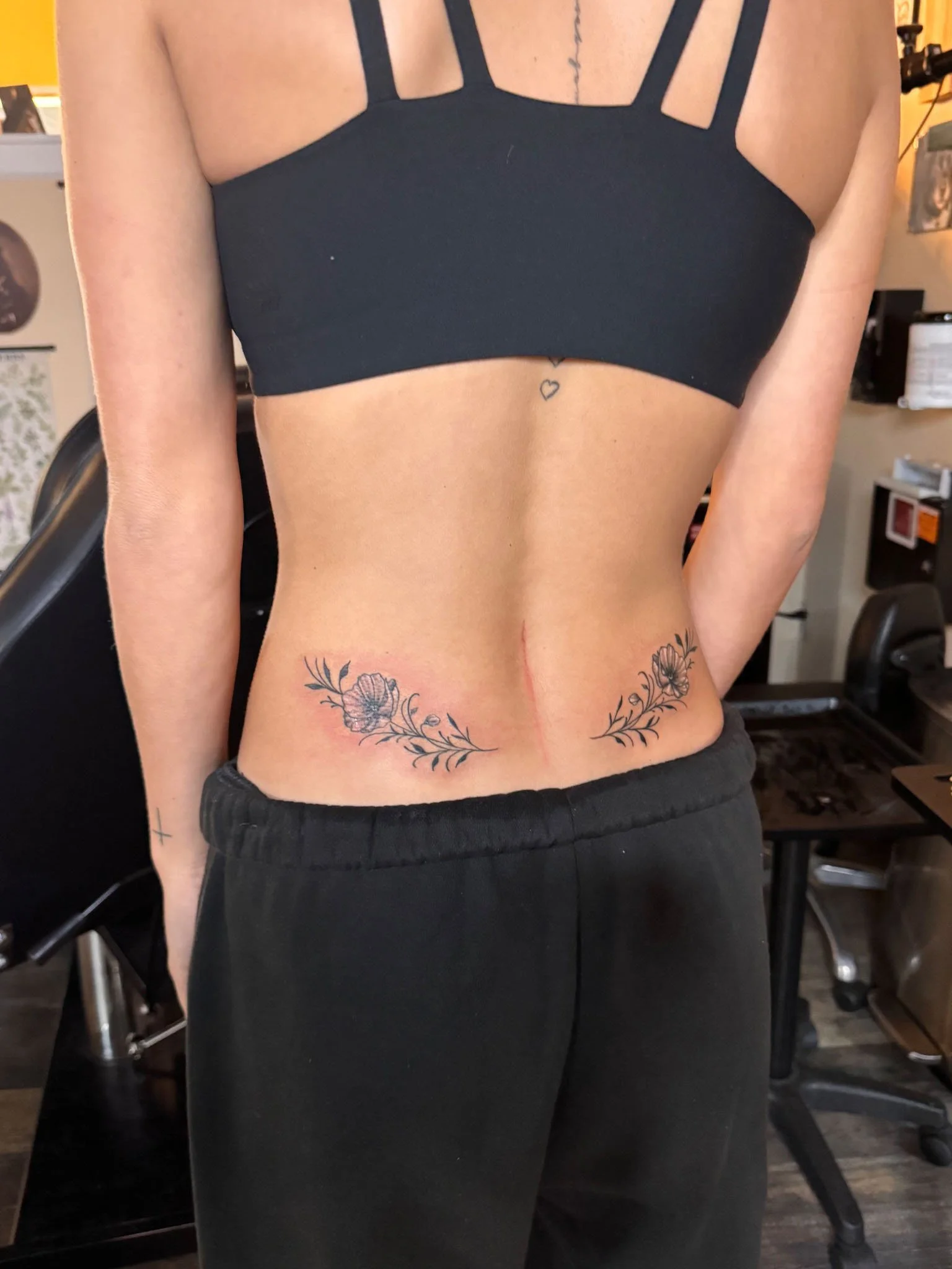 Small floral tattoo on a woman's lower back and hip
