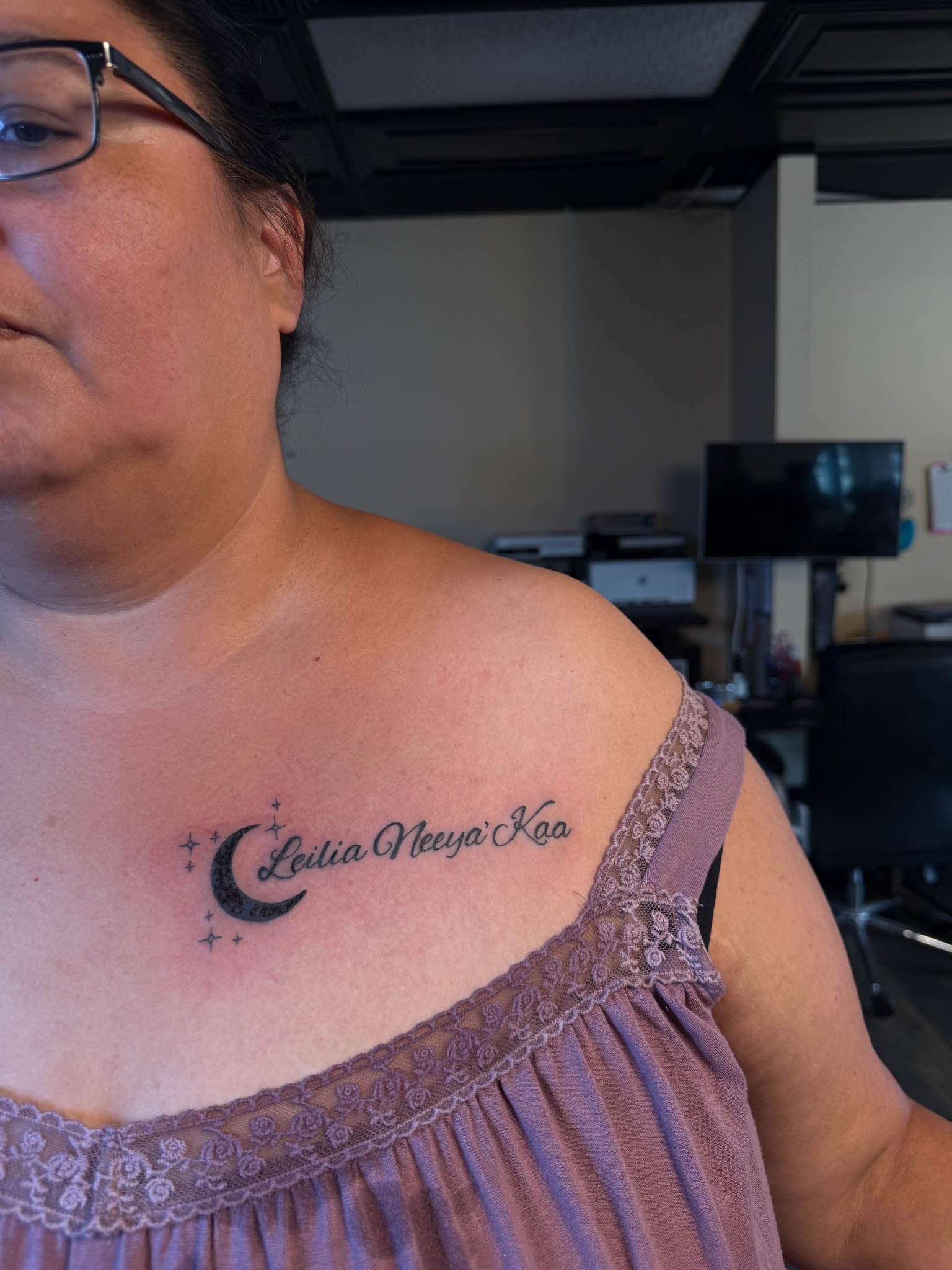 Script upper chest tattoo on a woman