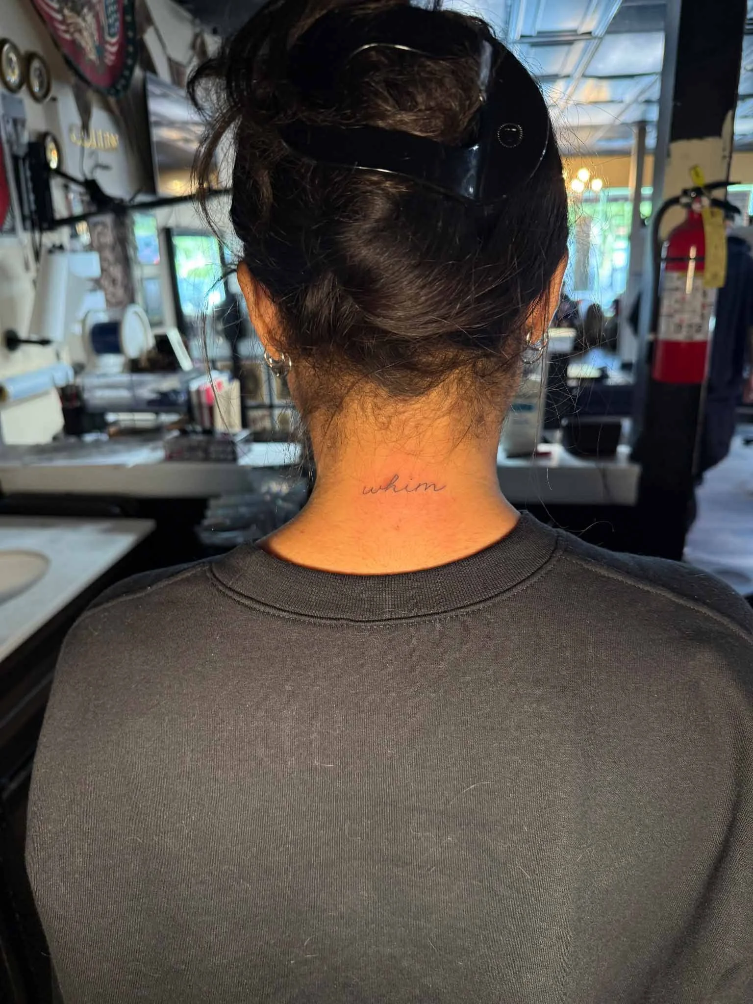 Back-of-neck script tattoo viewed from behind.
