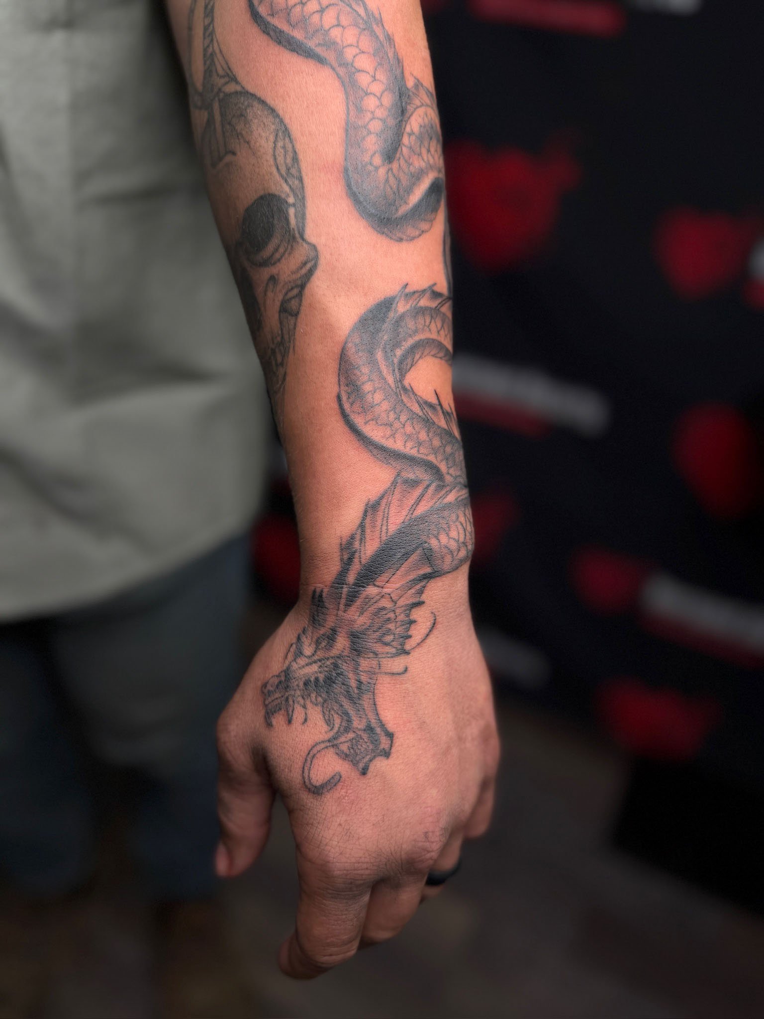 Tattoo of a dragon on a person's forearm.