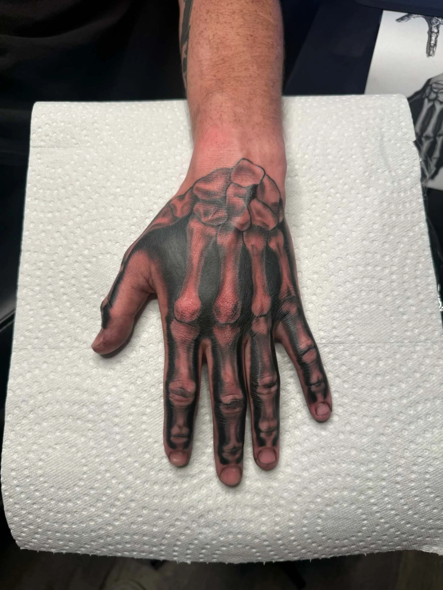Tattoo of a hand with internal bones and joints visible on the person's hand.